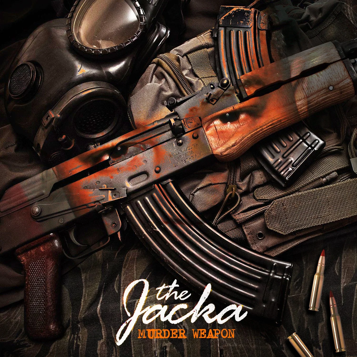 An AK-47 rifle with a worn finish lying on tactical gear next to a gas mask, bullets, and the text "the Jacka Murder Weapon."