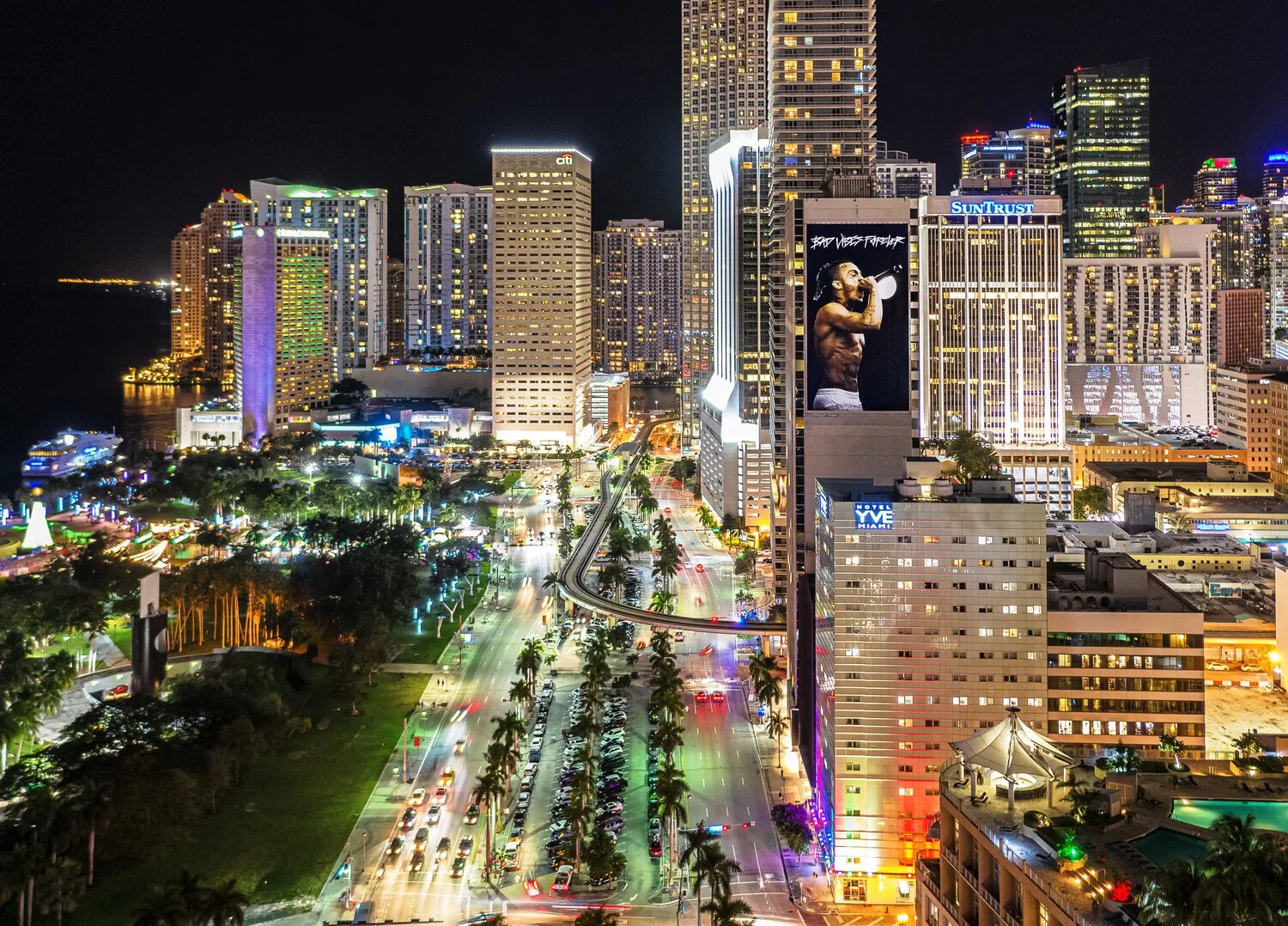 Aerial view of downtown Miami at night with illuminated skyscrapers and busy streets.
