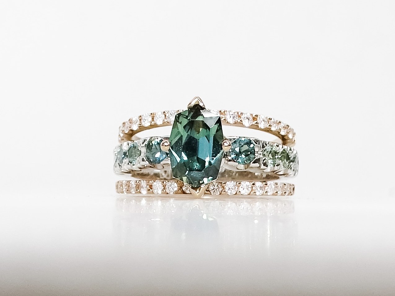 18ct rose gold and platinum custom cut parti sapphire ring with diamond set rails. 