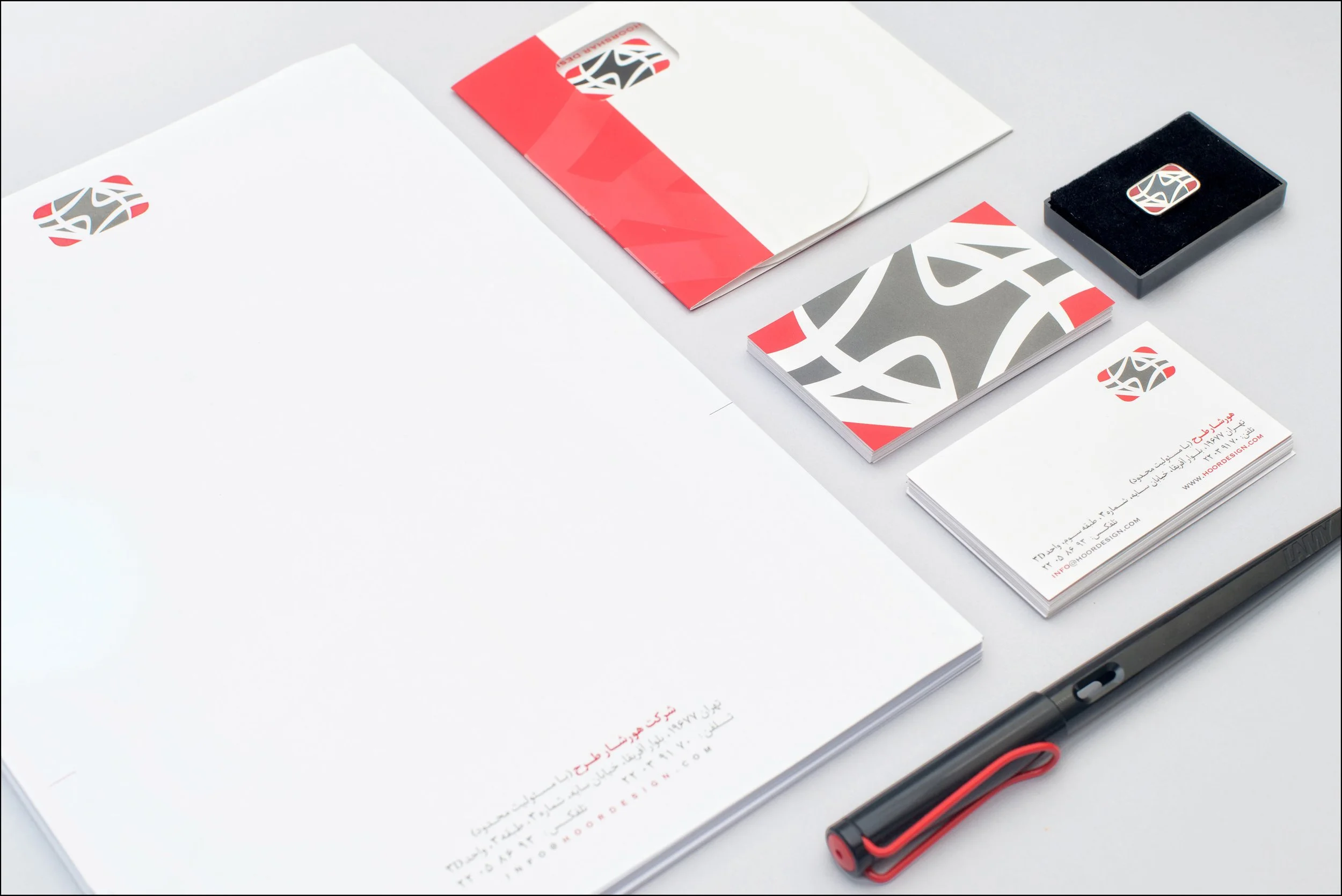Business stationery items including letterhead, business card, envelope, notepad, pen, and various branded materials featuring a logo with black, white, and red colors.
