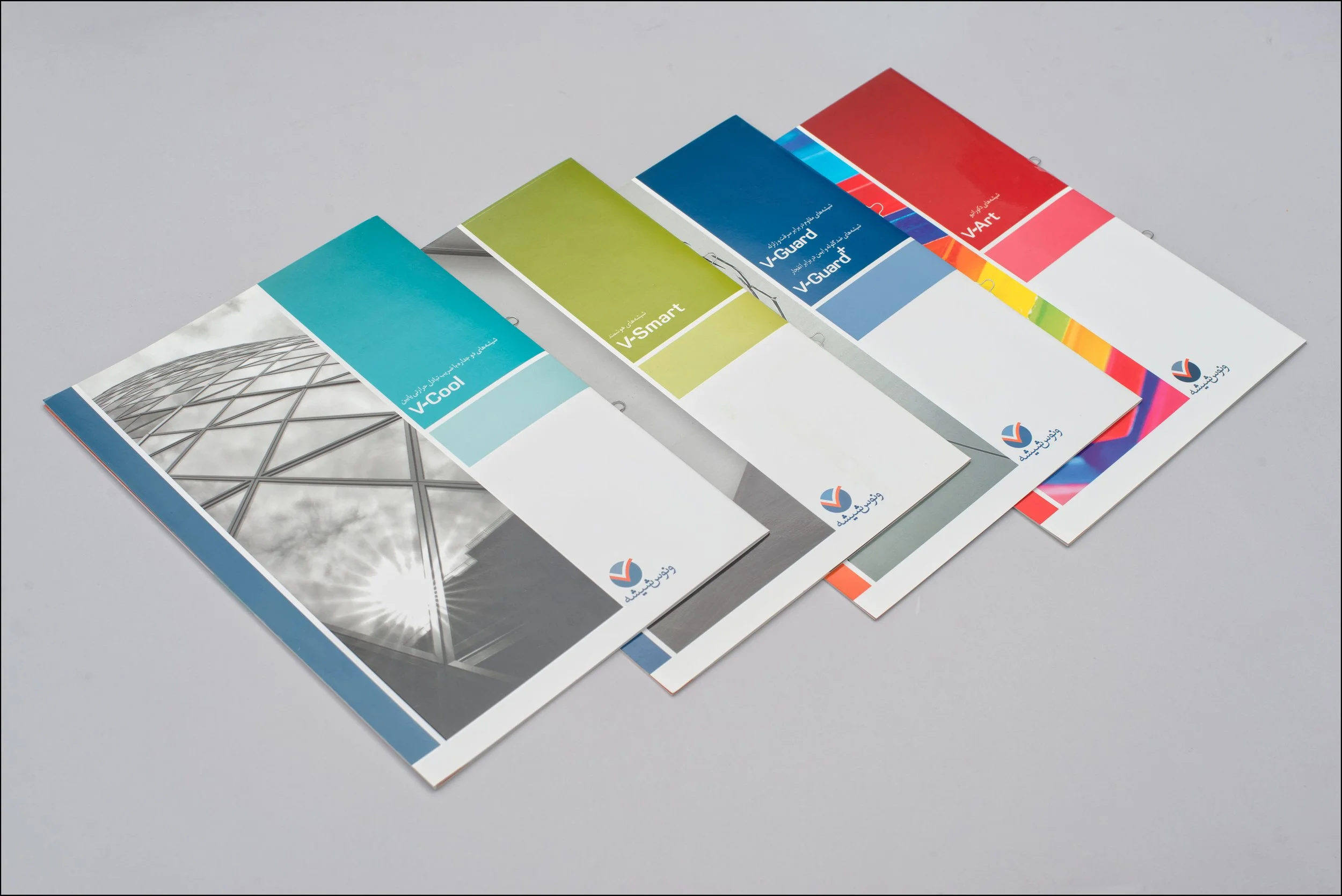 A set of four color swatch brochures labeled V-Cool, V-Smart, V-Guard, and V-Art arranged in a row on a light gray surface.