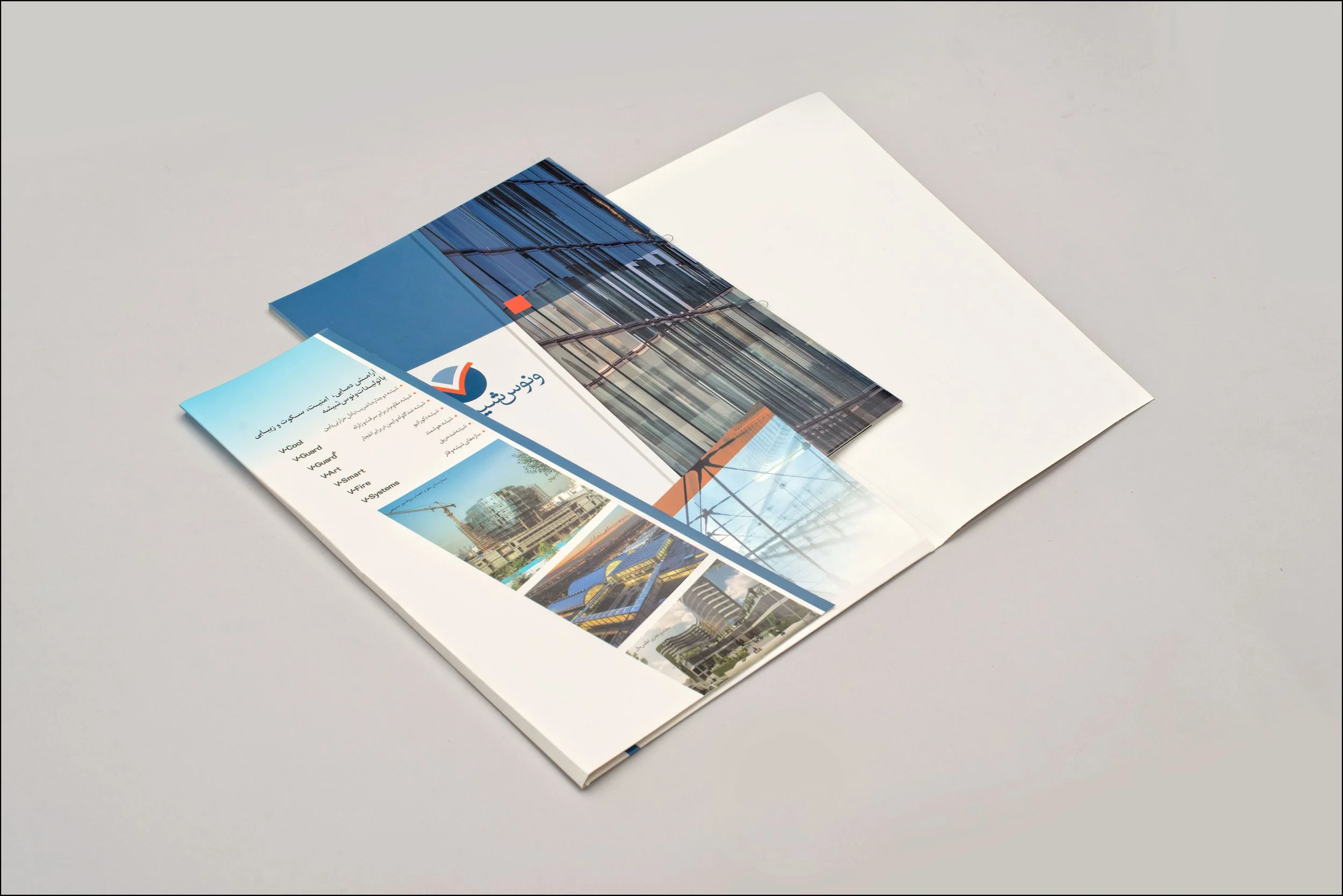 Open brochure or booklet with construction images and Arabic text on a light surface.