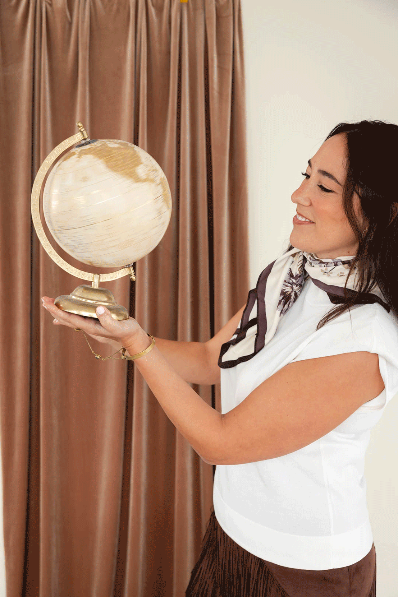 Noemí observando un globo terráqueo con expresión reflexiva, simbolizando el inicio del viaje interior y la decisión de mirar el mundo desde adentro.