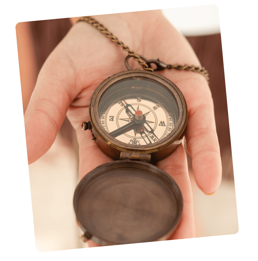Brújula antigua sostenida en la mano, símbolo de la guía interior que ayuda a redirigir el camino hacia una vida más alineada.