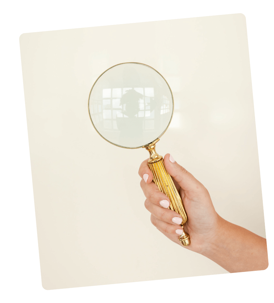 Mano sosteniendo una lupa dorada, simbolizando la observación consciente y la exploración profunda del mundo interior.