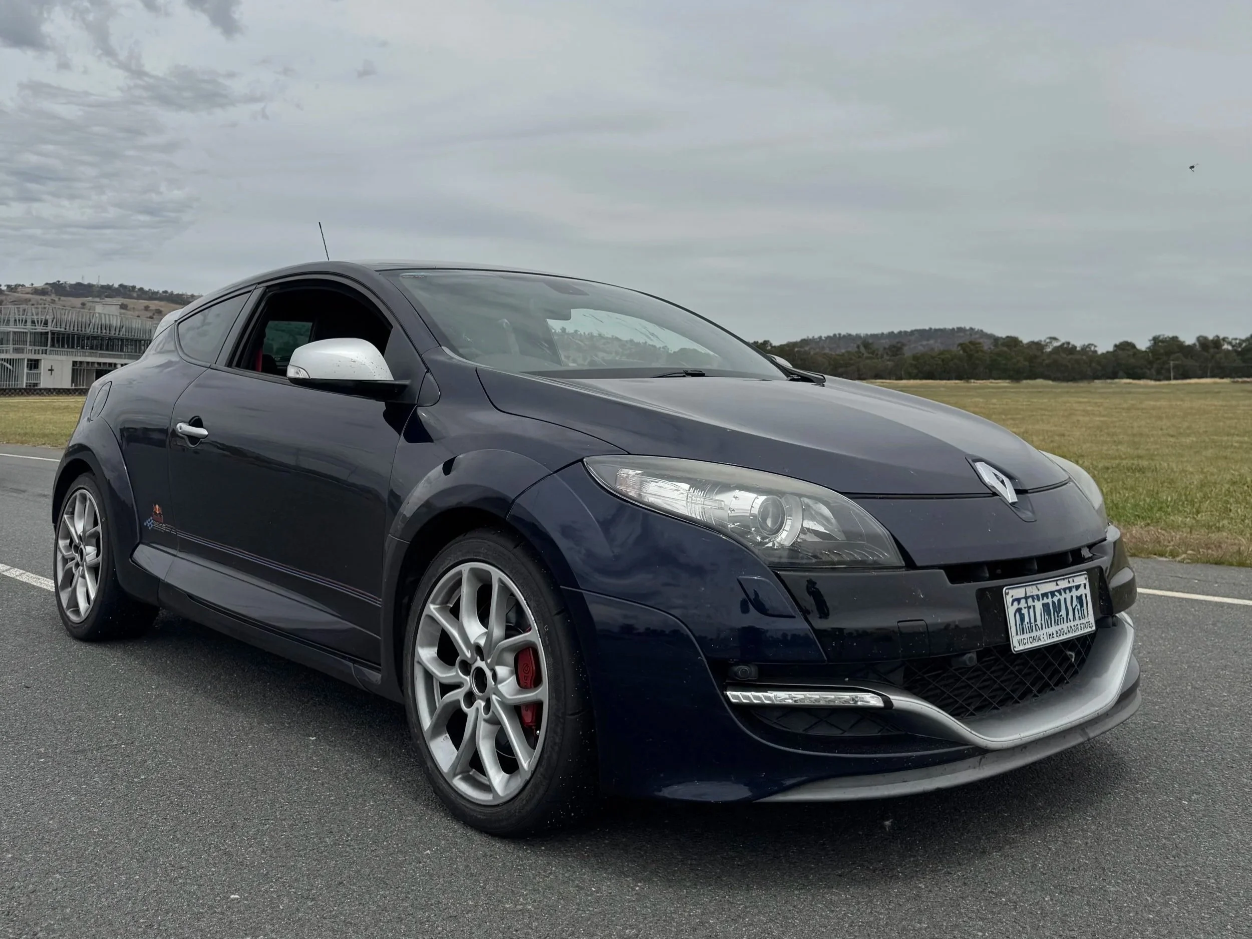 Mitch's 2L turbo manual RS megane Redbull edition has you wildly disappointed when you pull up next to it at the traffic lights finding a tradie driving. However this thing absolutely rips it up on the track, just like its brake pads, but who needs t