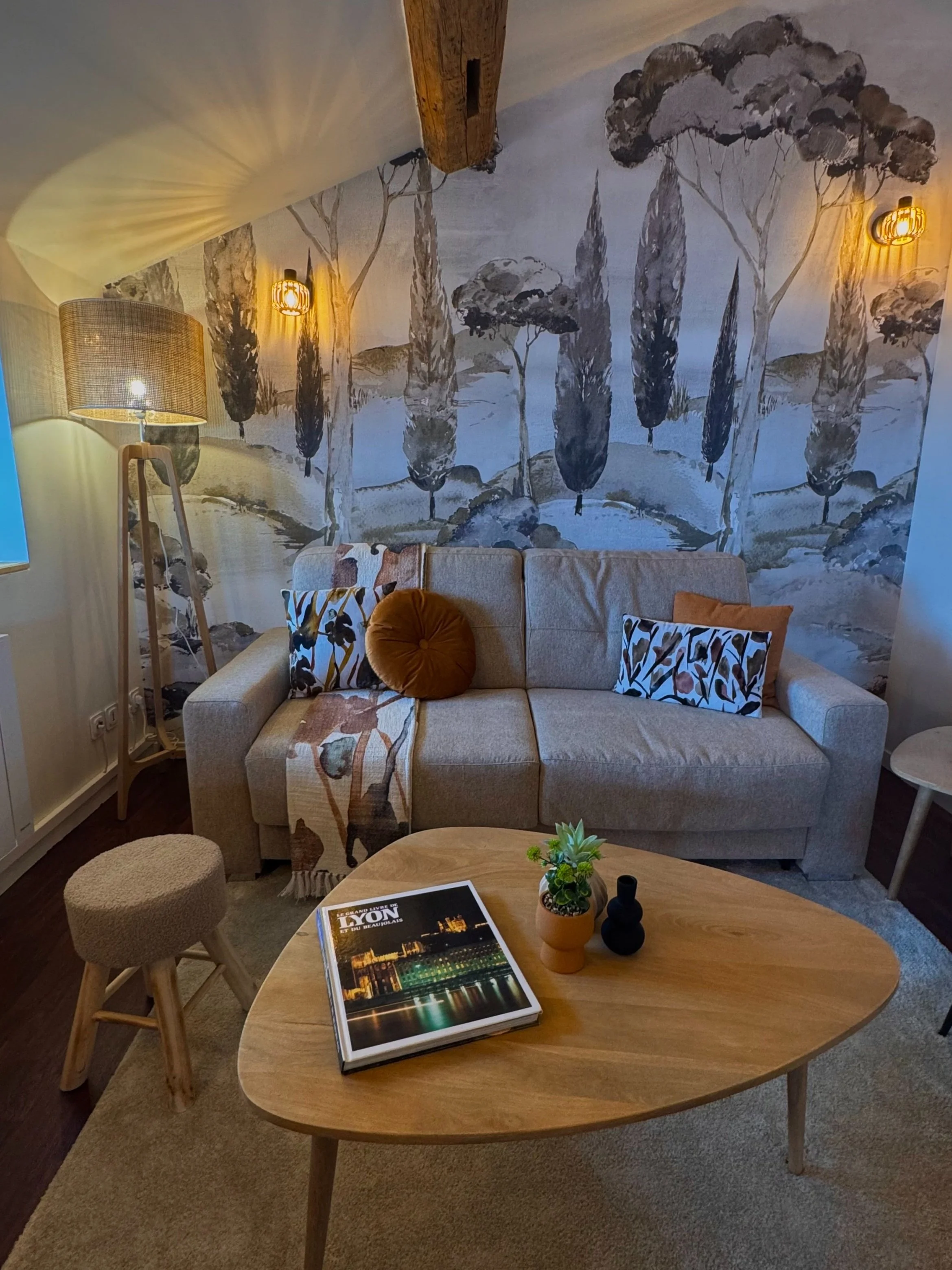 Salon de la Suite Cocon, décoré d’un paysage toscan : un cadre apaisant pour découvrir Lyon tout en profitant d’un intérieur plein de charme.