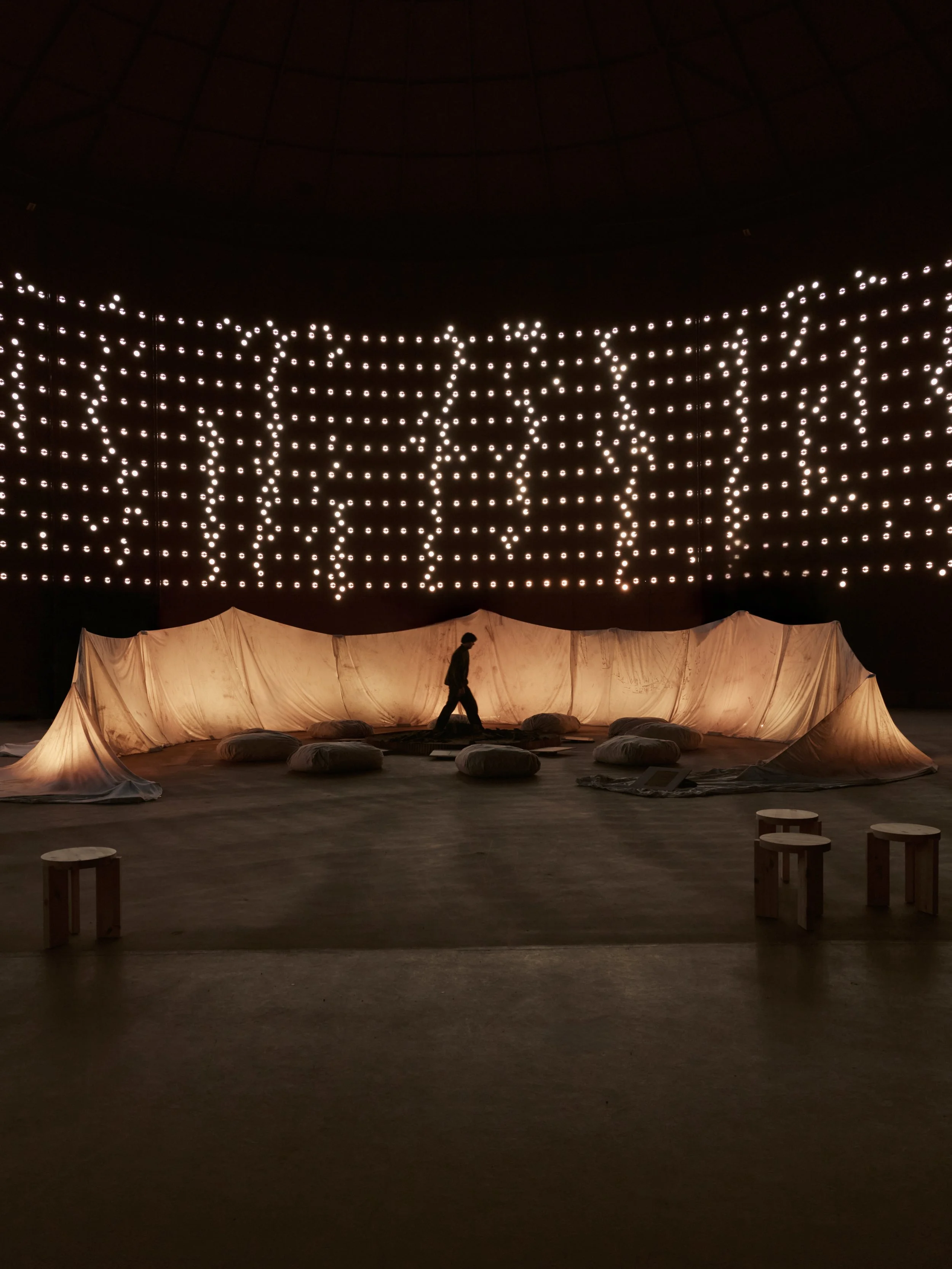 Tyyni is an experiential sound and spatial installation set inside Öljysäiliö 468, a monumental former oil silo in Helsinki. Drawing on the scale and atmosphere of the space, the installation formed a landscape of sand dunes, suspended textiles and s