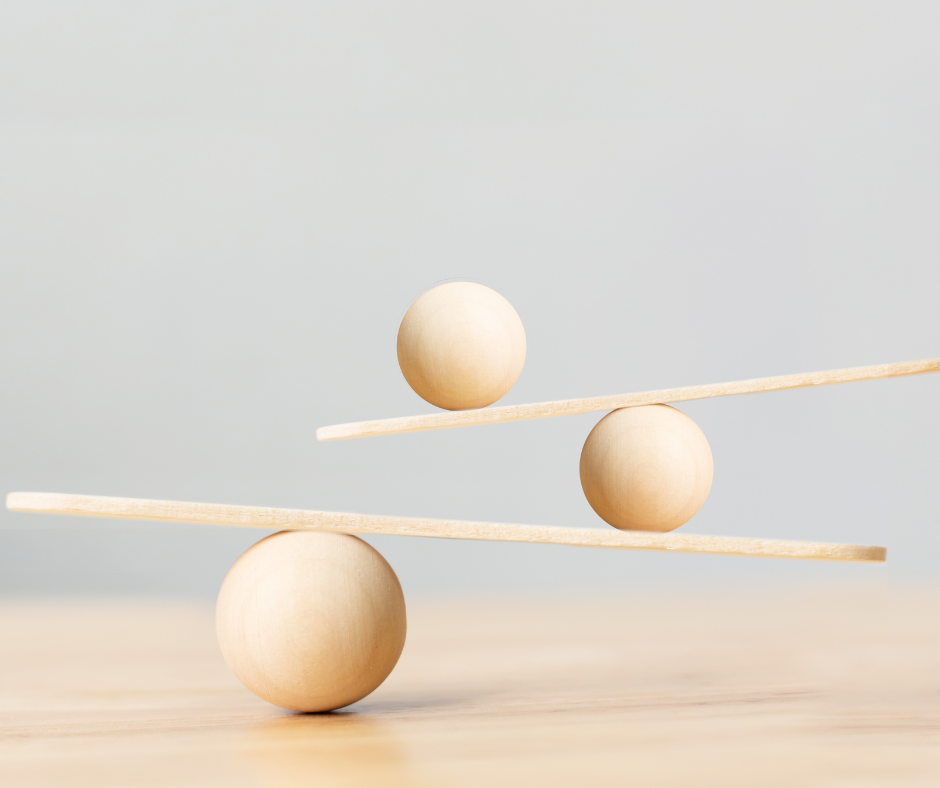 : Houten balansobject met bollen op plankjes, symbool voor balans en evenwicht.