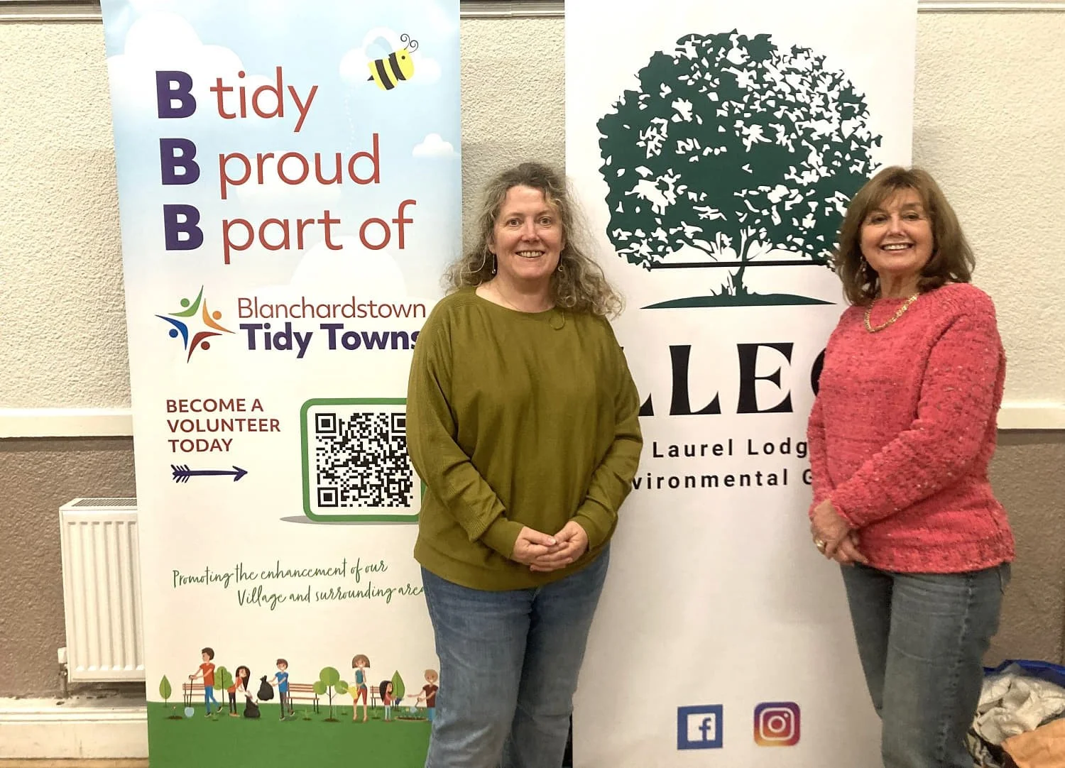 Laurel Lodge Environmental Group partners - Two women from Blanchardstown Tidy Towns standing indoors in front of groups banners.