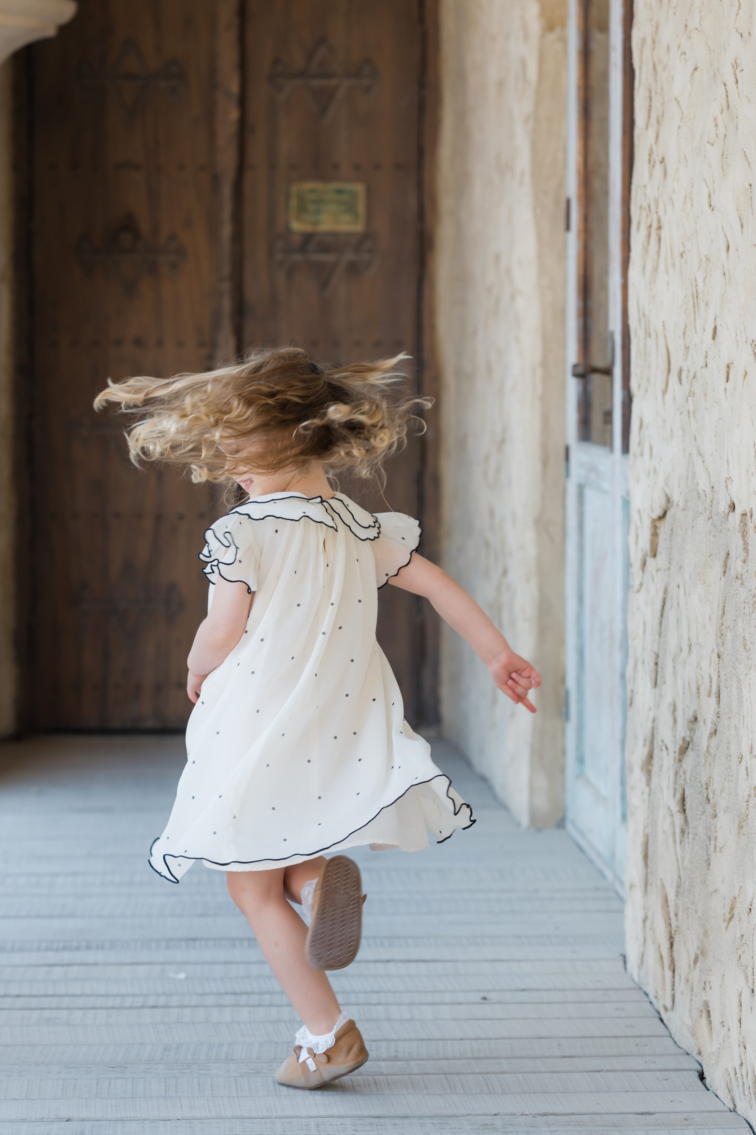 Little girl spinning in a dress during a lifestyle family photography session in Dubai