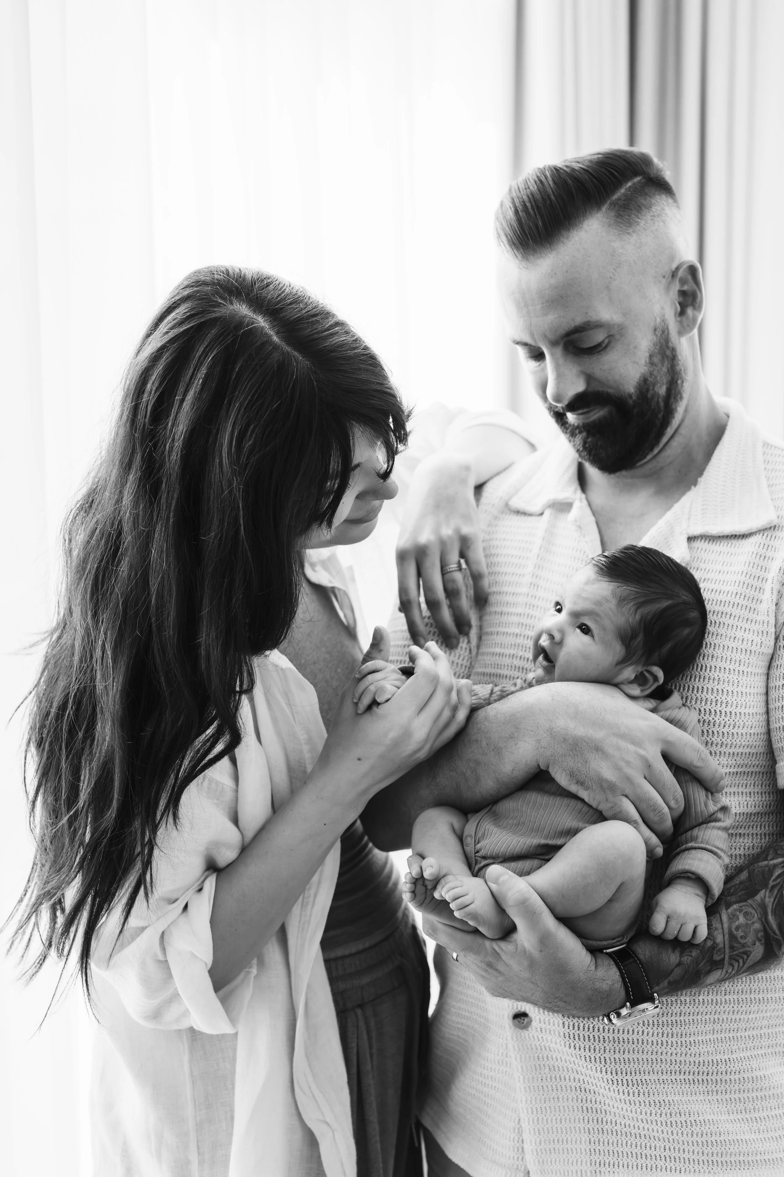 Black and white portrait of parents holding their newborn baby during a Dubai newborn session