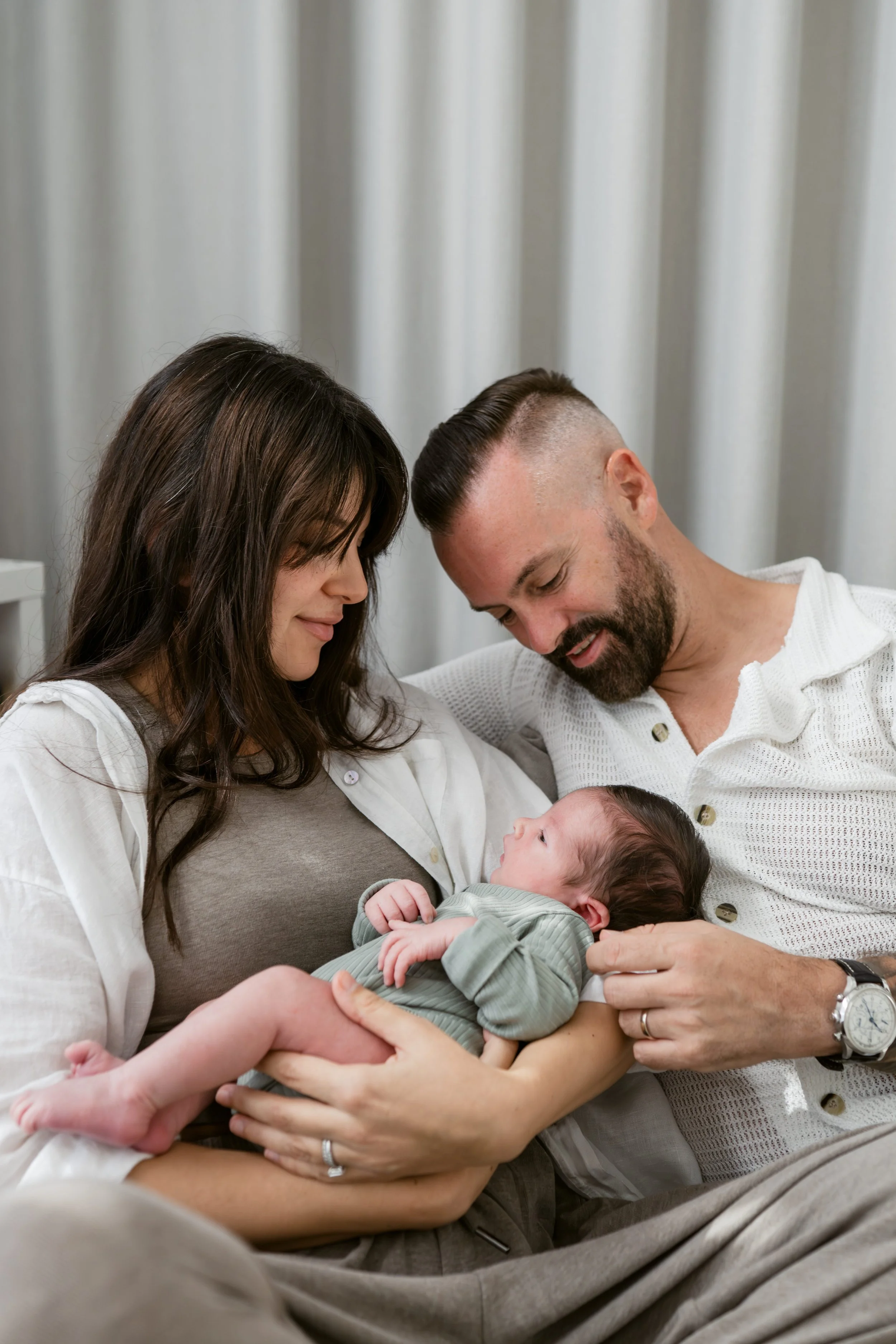 Parents holding their baby during a natural newborn lifestyle photography session in Dubai