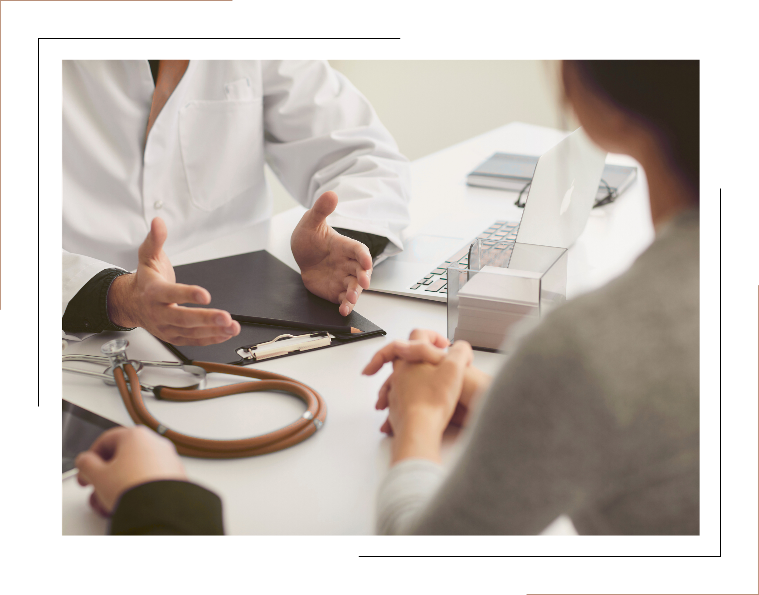 Doctor and patient having a consultation in an office, with medical notes, a stethoscope, and a laptop on the desk.
