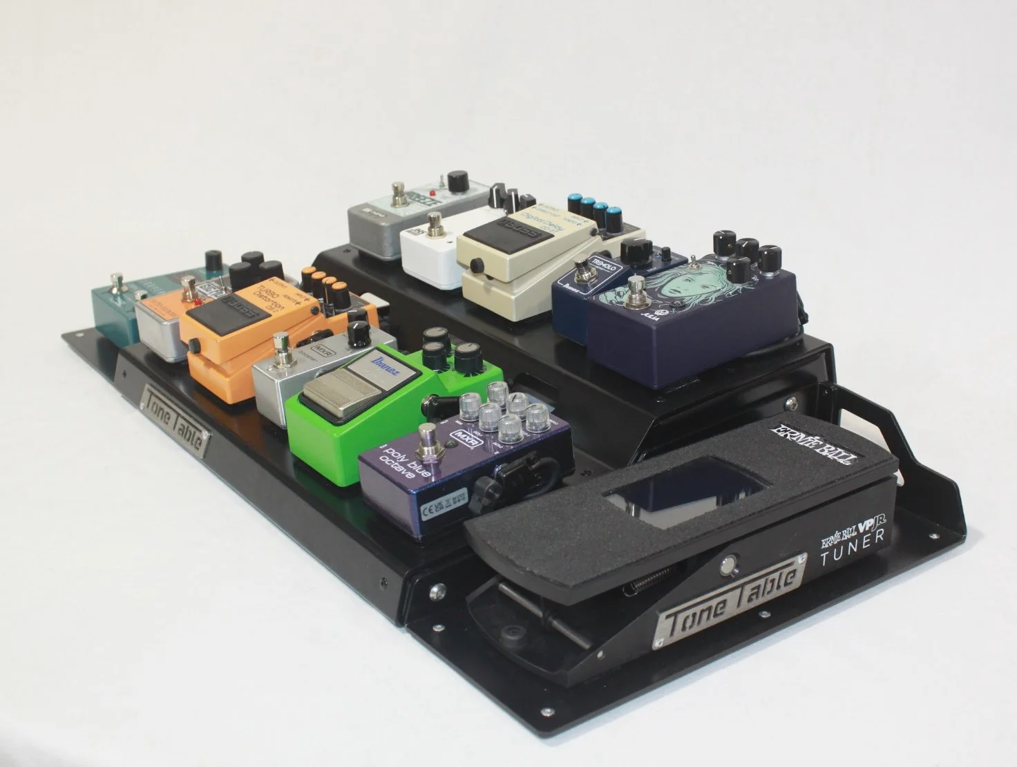 A collection of colorful guitar effect pedals arranged on a black pedalboard, labeled 'Tone Table' for guitar tone adjustments.
