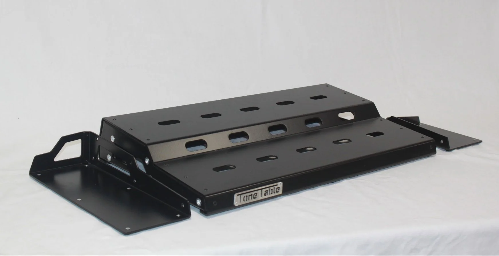 A black tactical metal gaming or utility platform with adjustable height and multiple mounting holes, labeled 'Time Talle'.