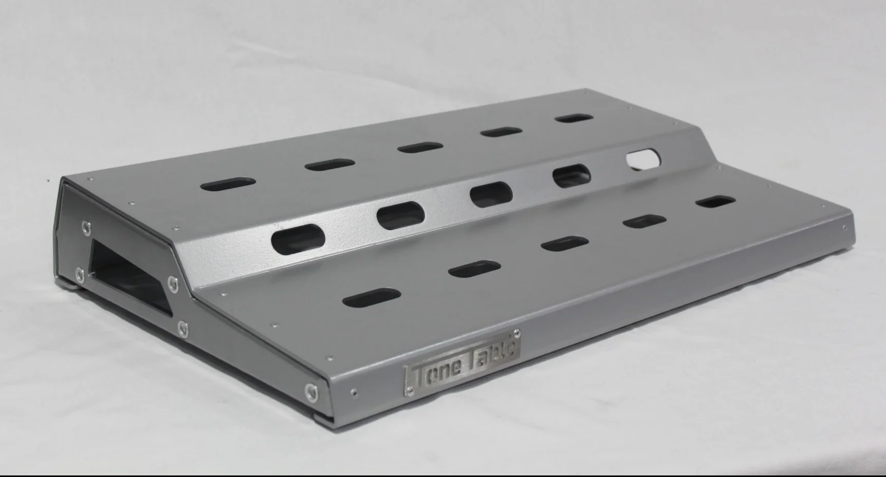 A metallic pedal with multiple holes and a label reading 'ToneTal'.