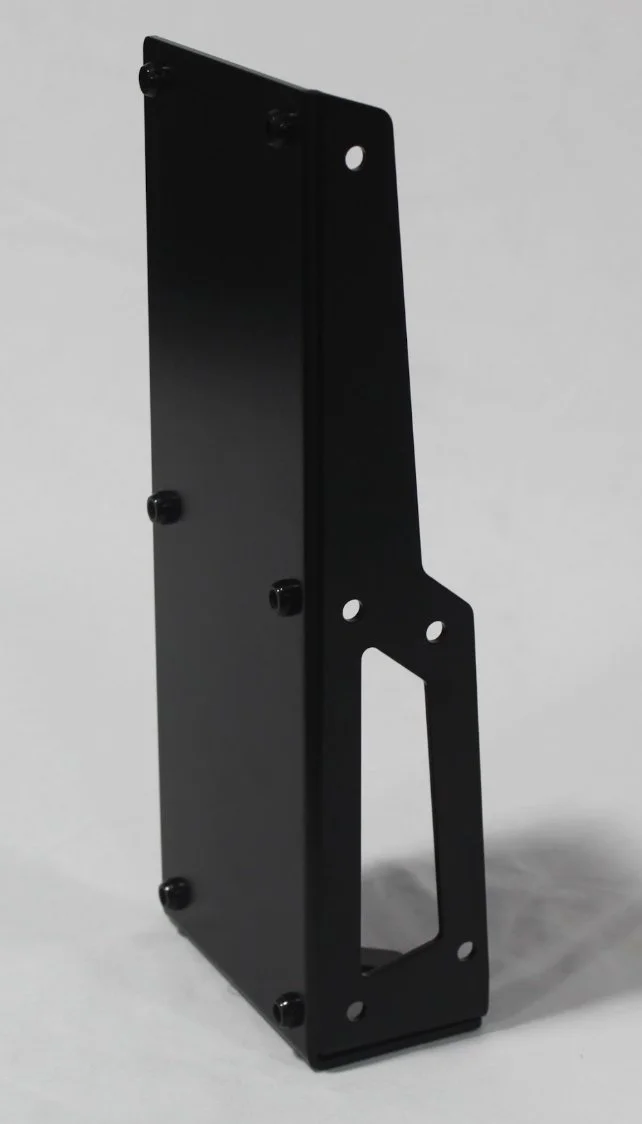 Black industrial metal bracket or mounting plate with multiple holes, standing upright on a white surface.