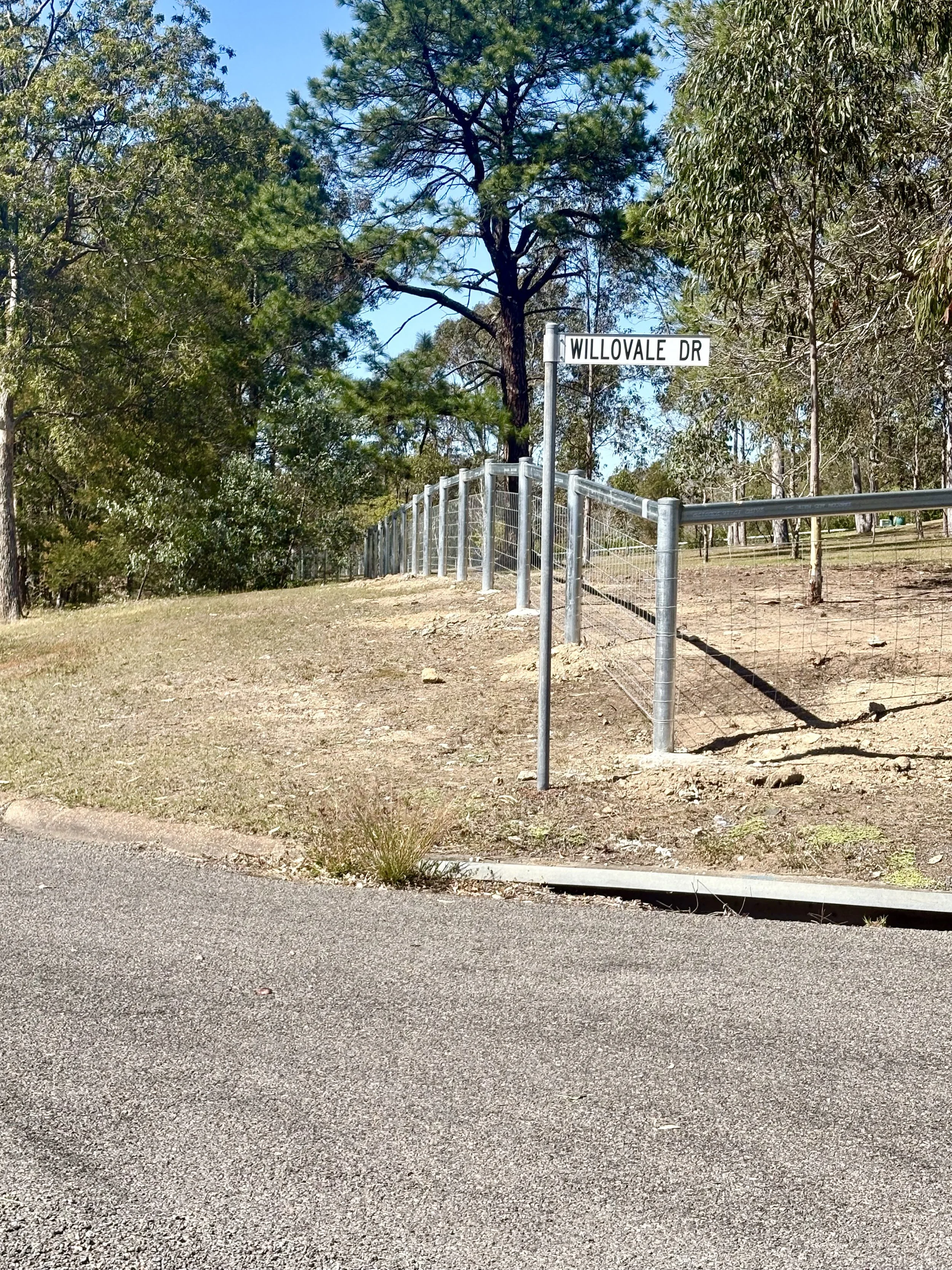 Corner view shot of post and rail rural fence installed with hinge joint wire