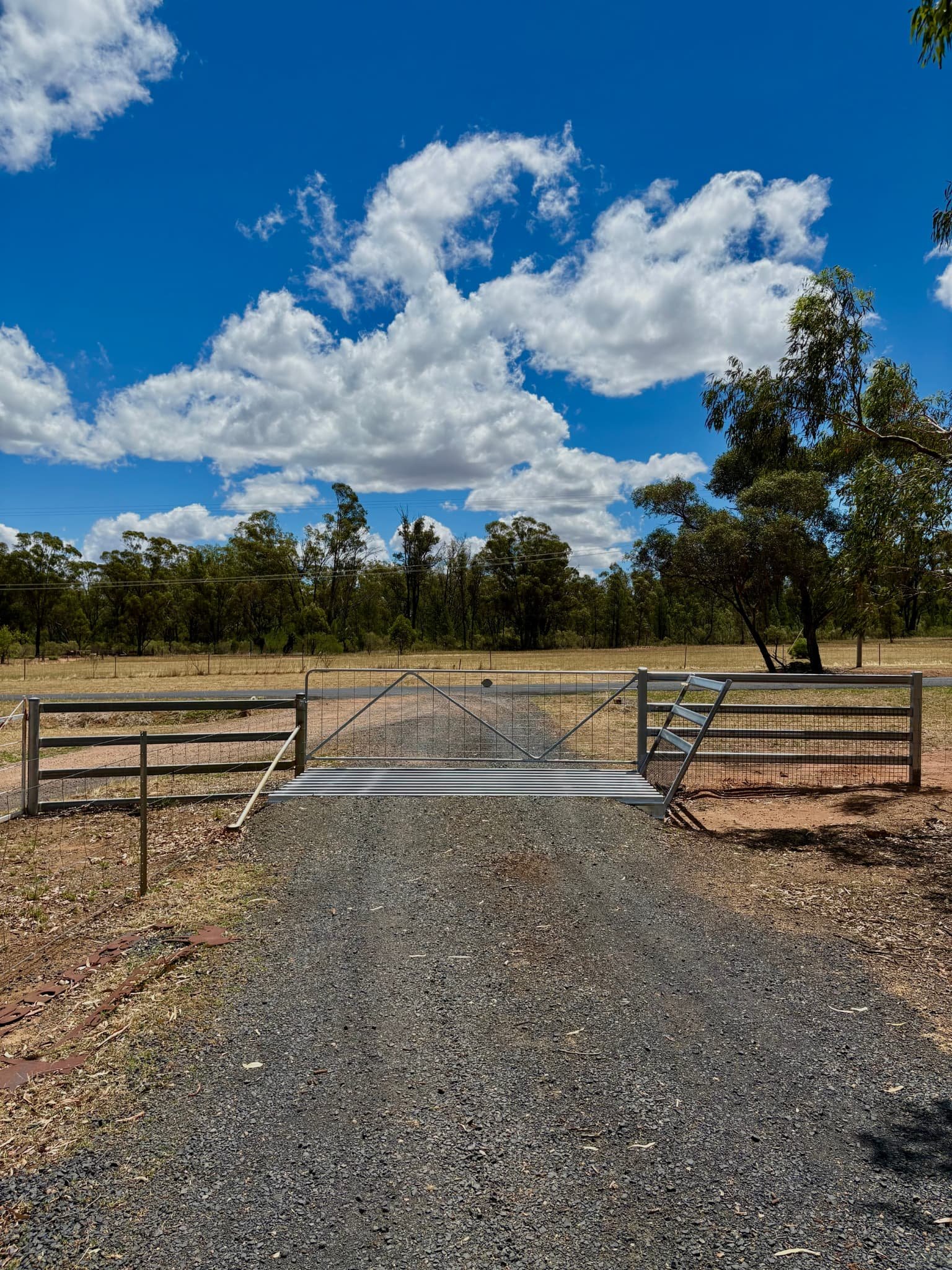 Rural property front entry with cattle grid, cattle rail and swinging gate, agricultural fencing NSW