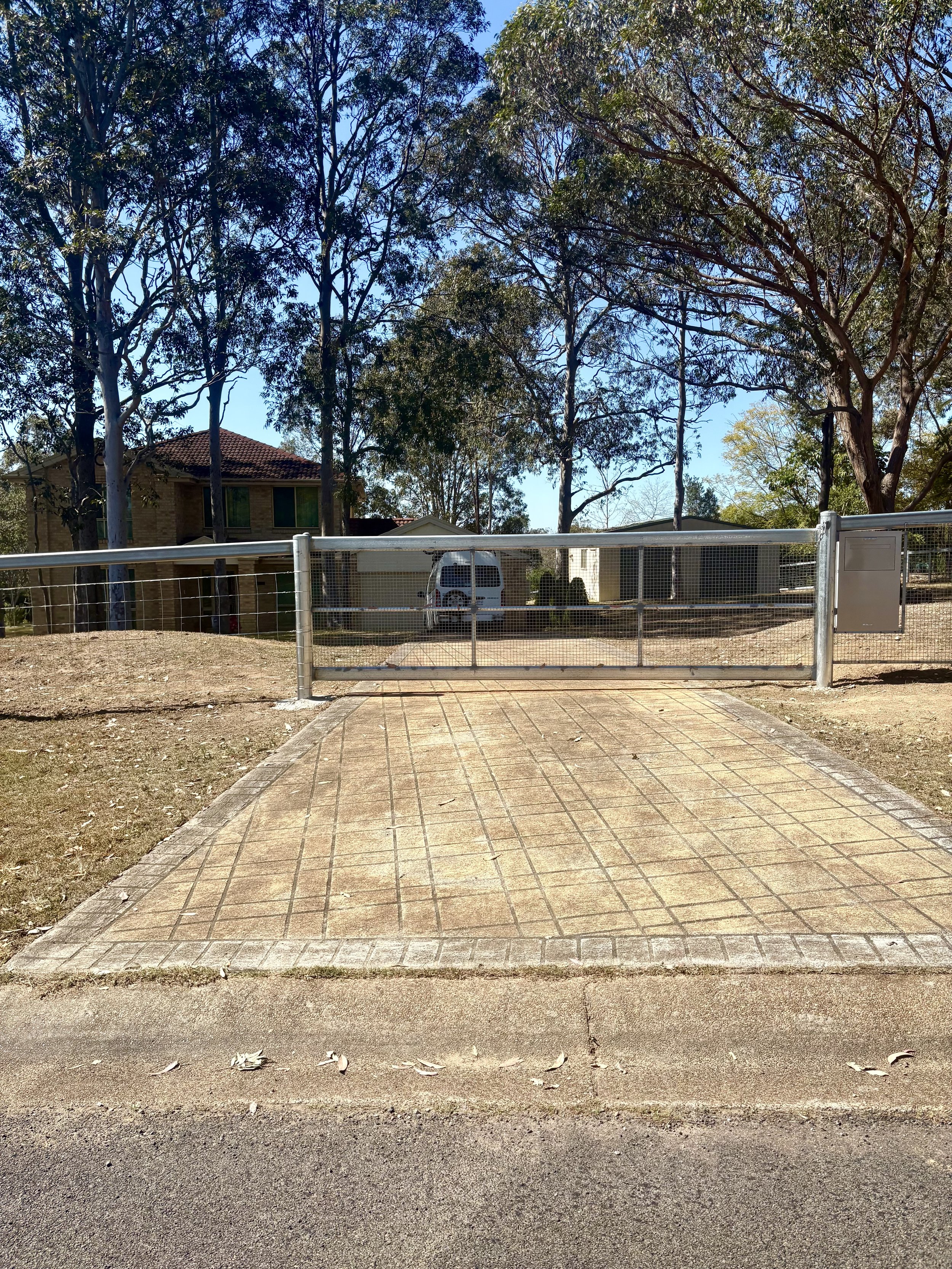 Custom built cattle rail gate front entrance with custom letterbox installed by TG Wheeler Contracting