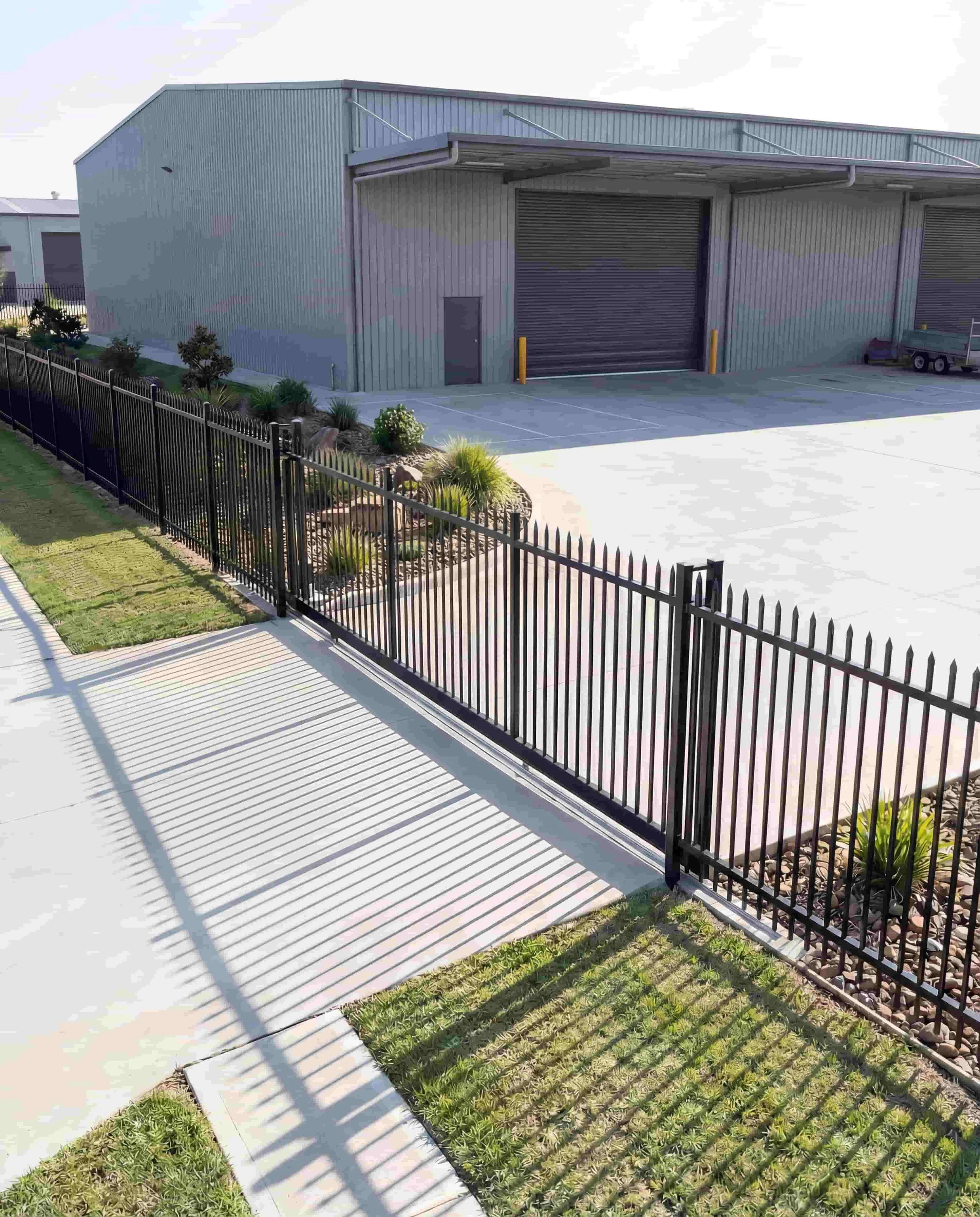 Elevated view of black steel automatic sliding gate with spear tops at commercial shed entrance, Northern Rivers NSW