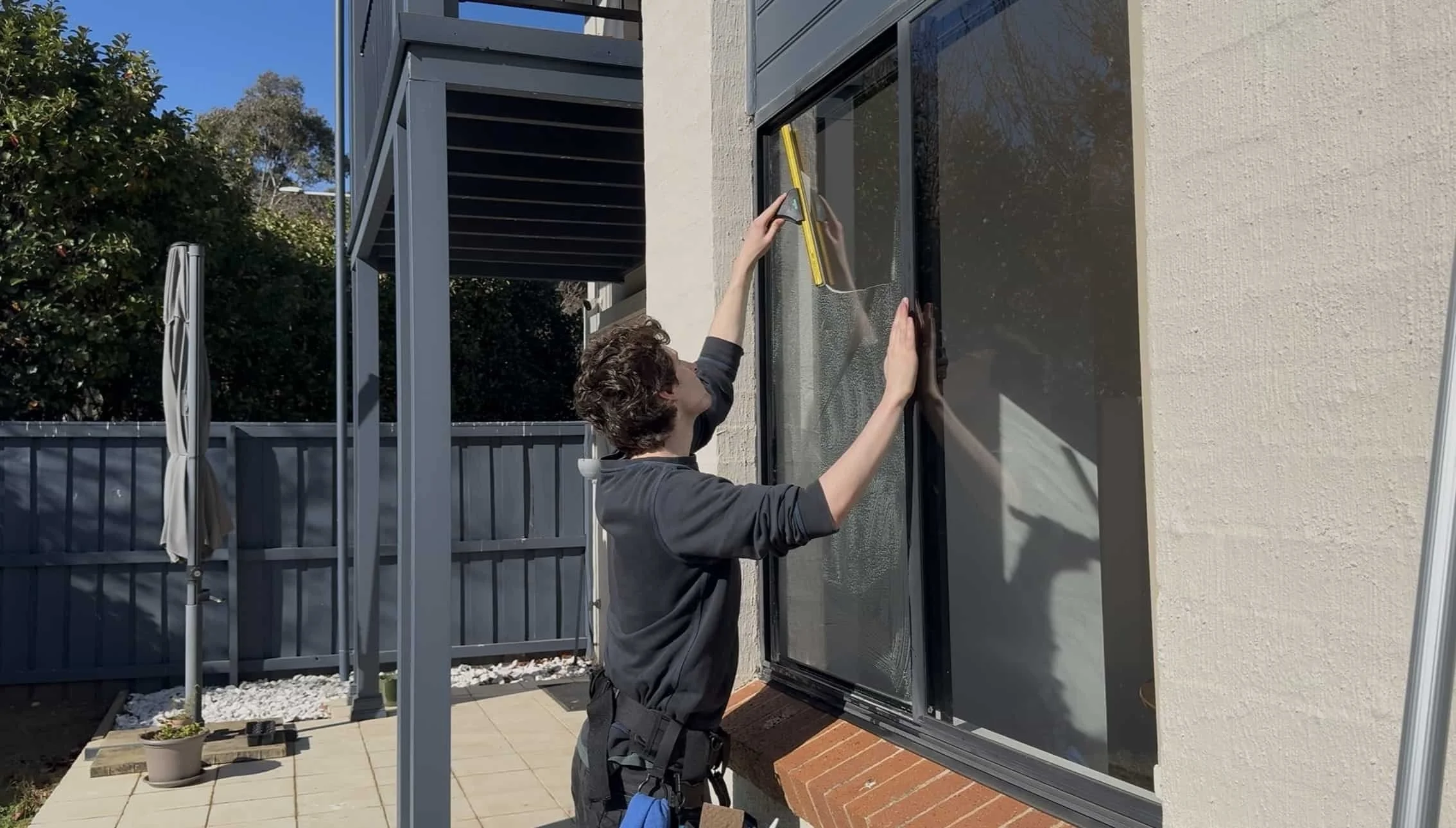Person cleaning window outside with a squeegee
