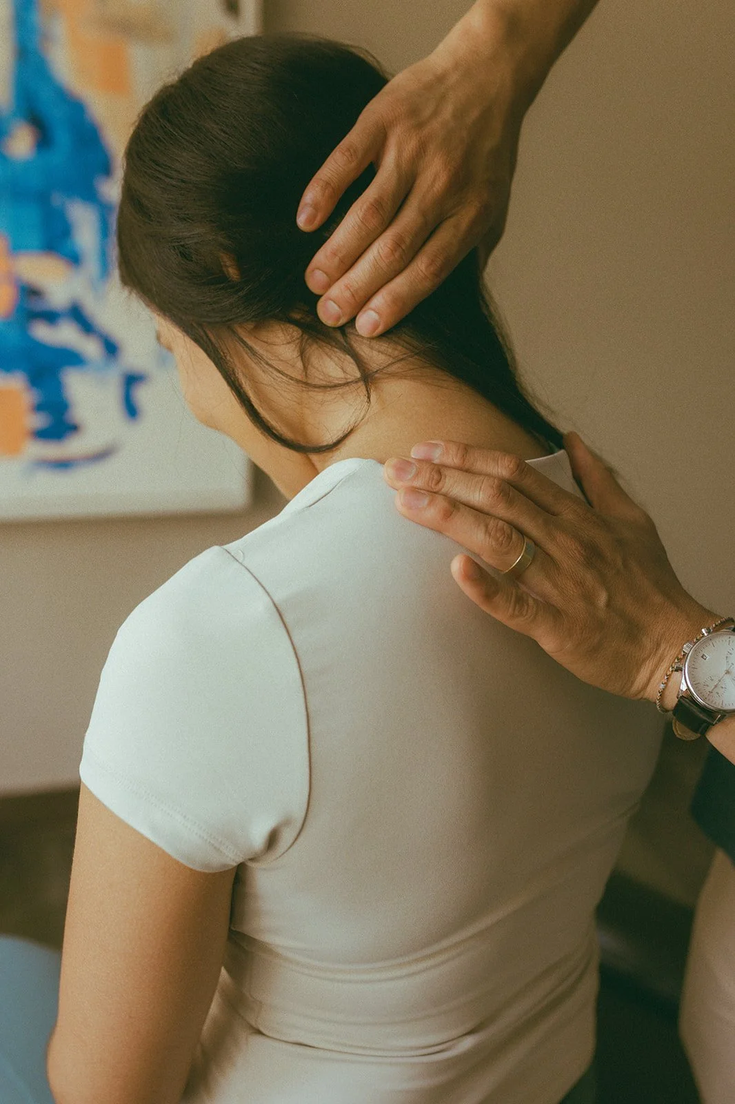 Provider supporting upper back and shoulder tension during a Healcove treatment session in San Diego.