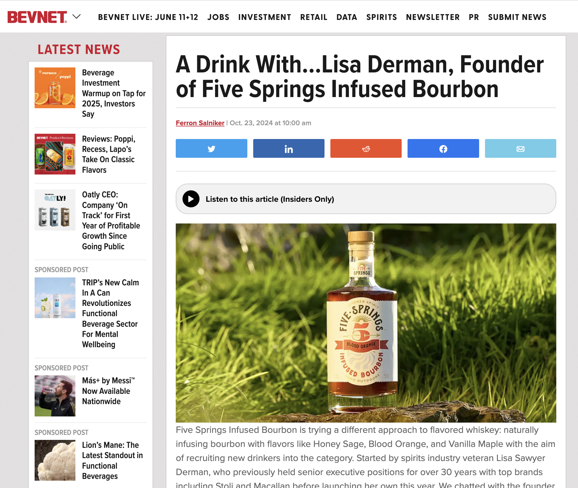 Bottle of Five Springs infused bourbon placed outdoors on a grassy surface with a blurred green background.