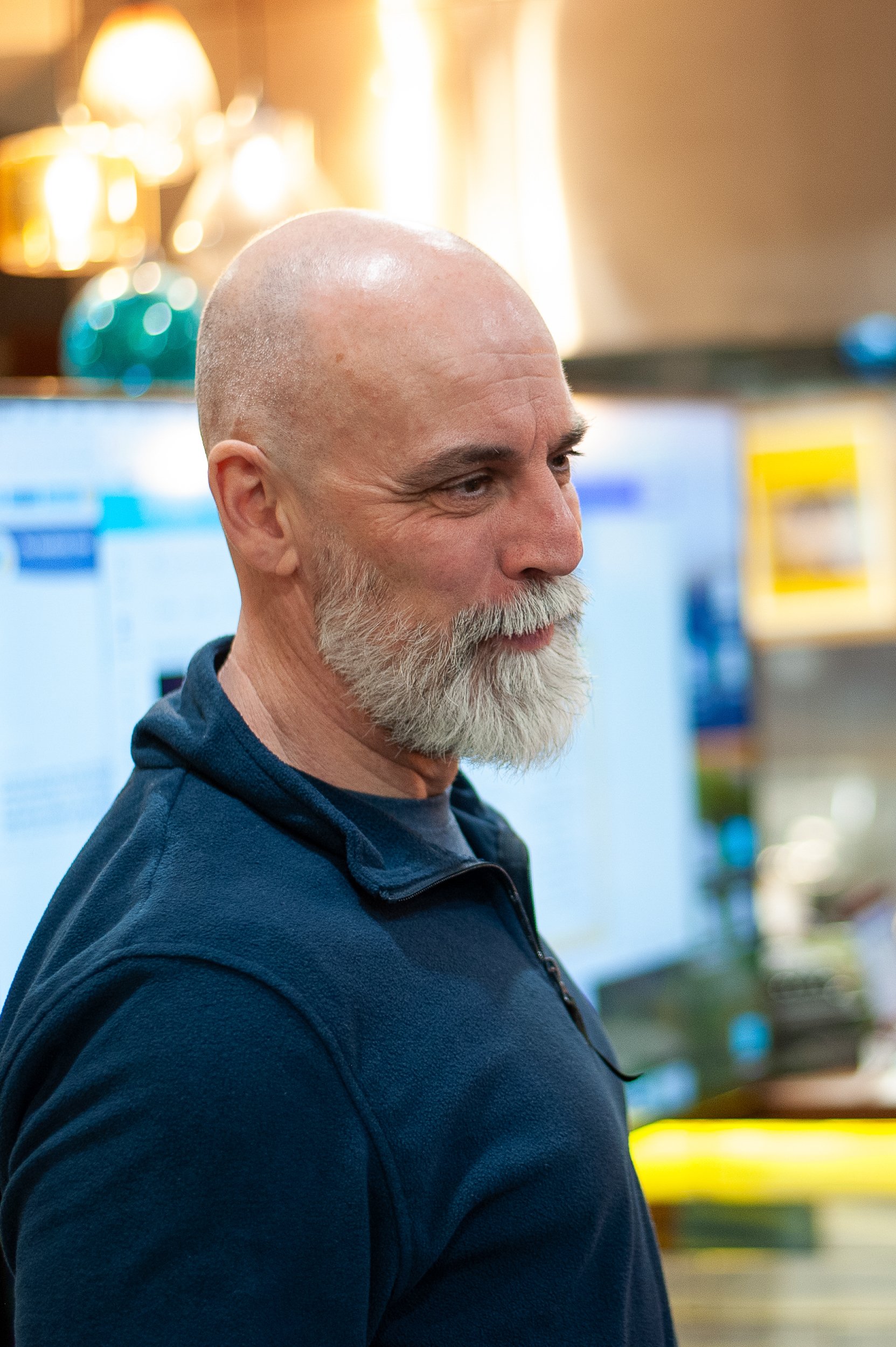 Bald man with a gray beard in a blue shirt