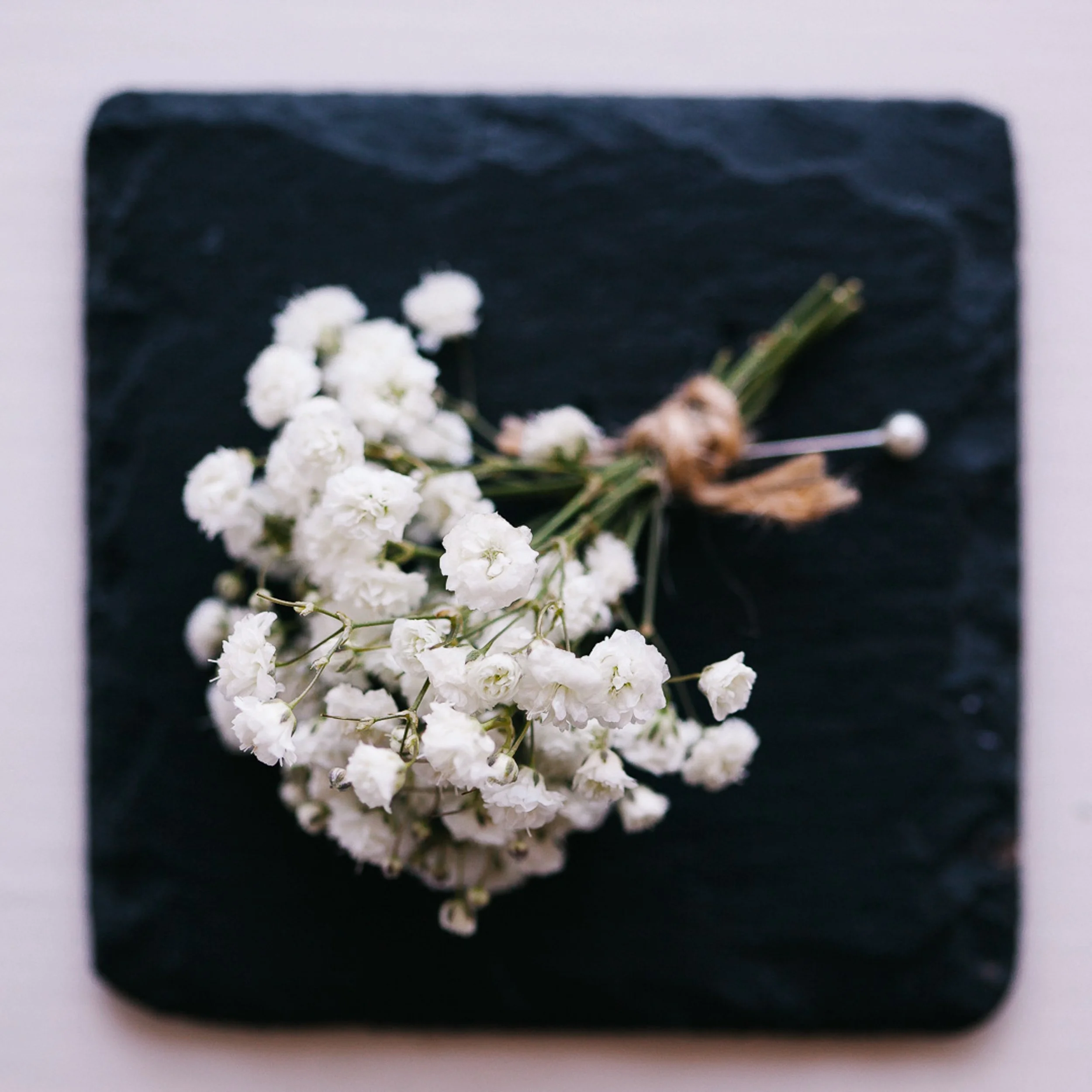 Bouquet of white baby's breath flowers on a dark slate surface