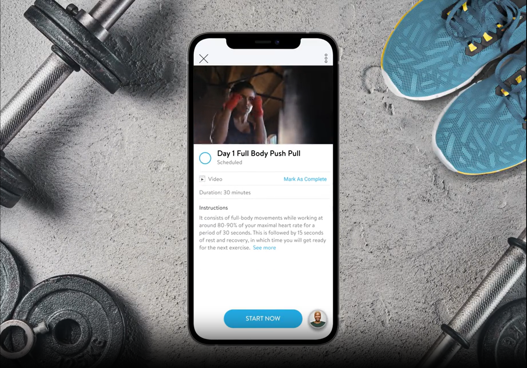 Smartphone displaying a workout app with a woman in workout clothes, blue athletic shoes, and dumbbells on a rough concrete surface.