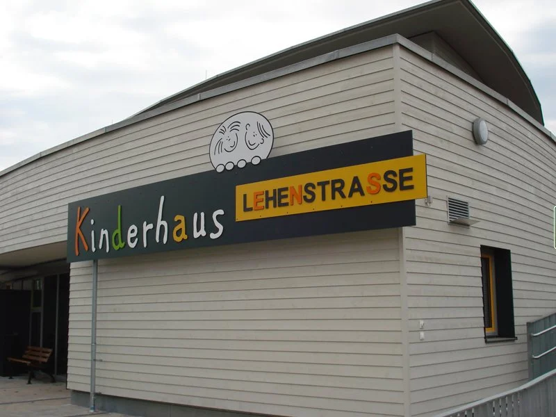 Gebäudefront mit bunter Beschilderung für ein Kinderhaus, das an der Lehenstraße liegt.
