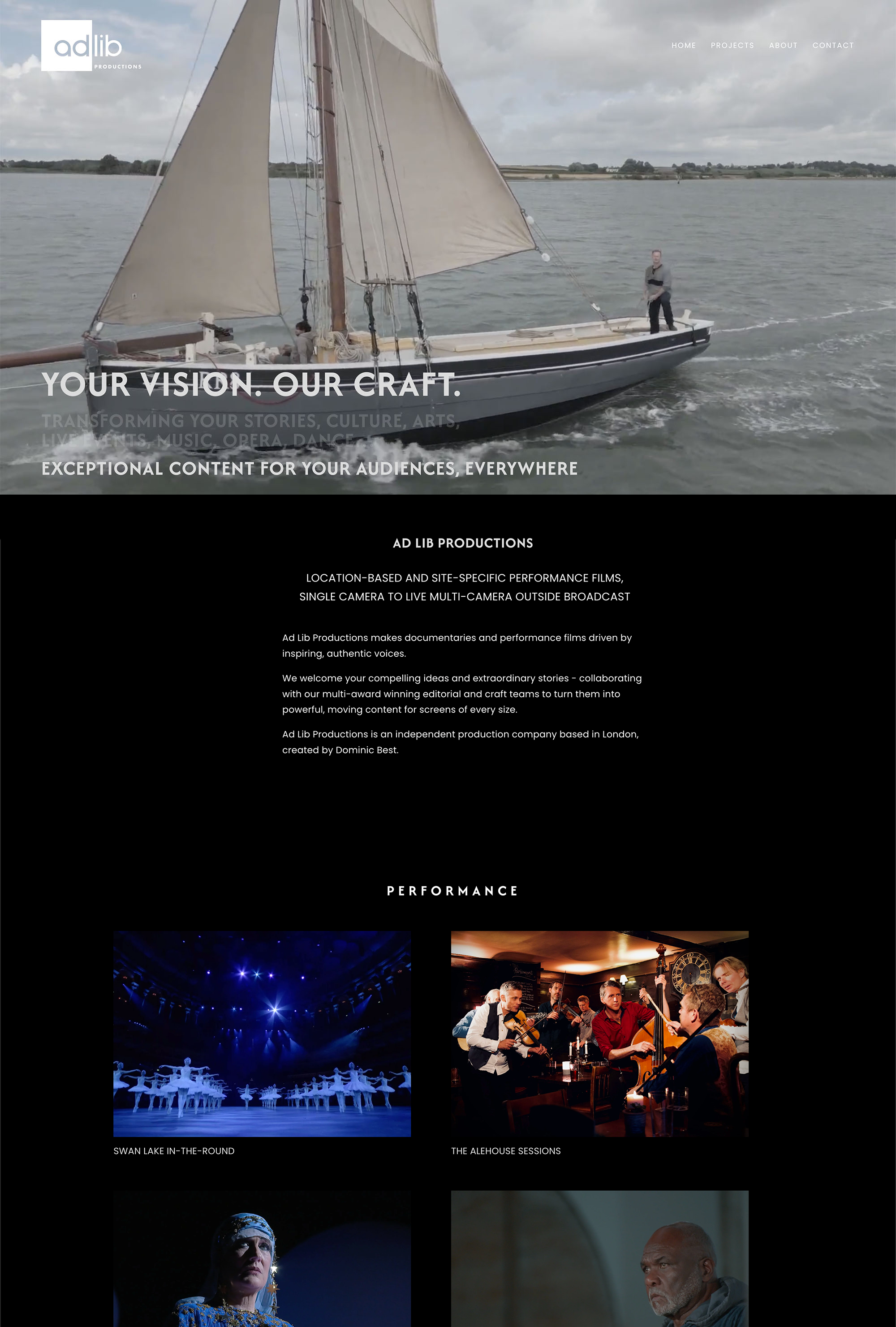 A sailboat on a body of water with a person standing on the bow, under a cloudy sky.