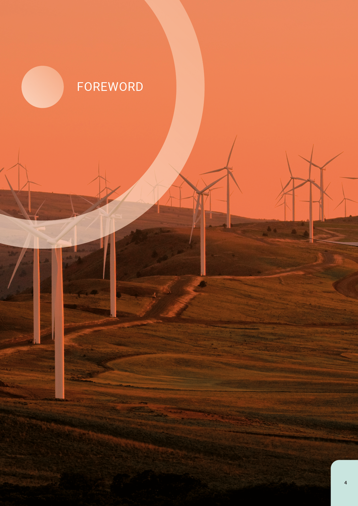 Hillside landscape at sunset with multiple wind turbines.