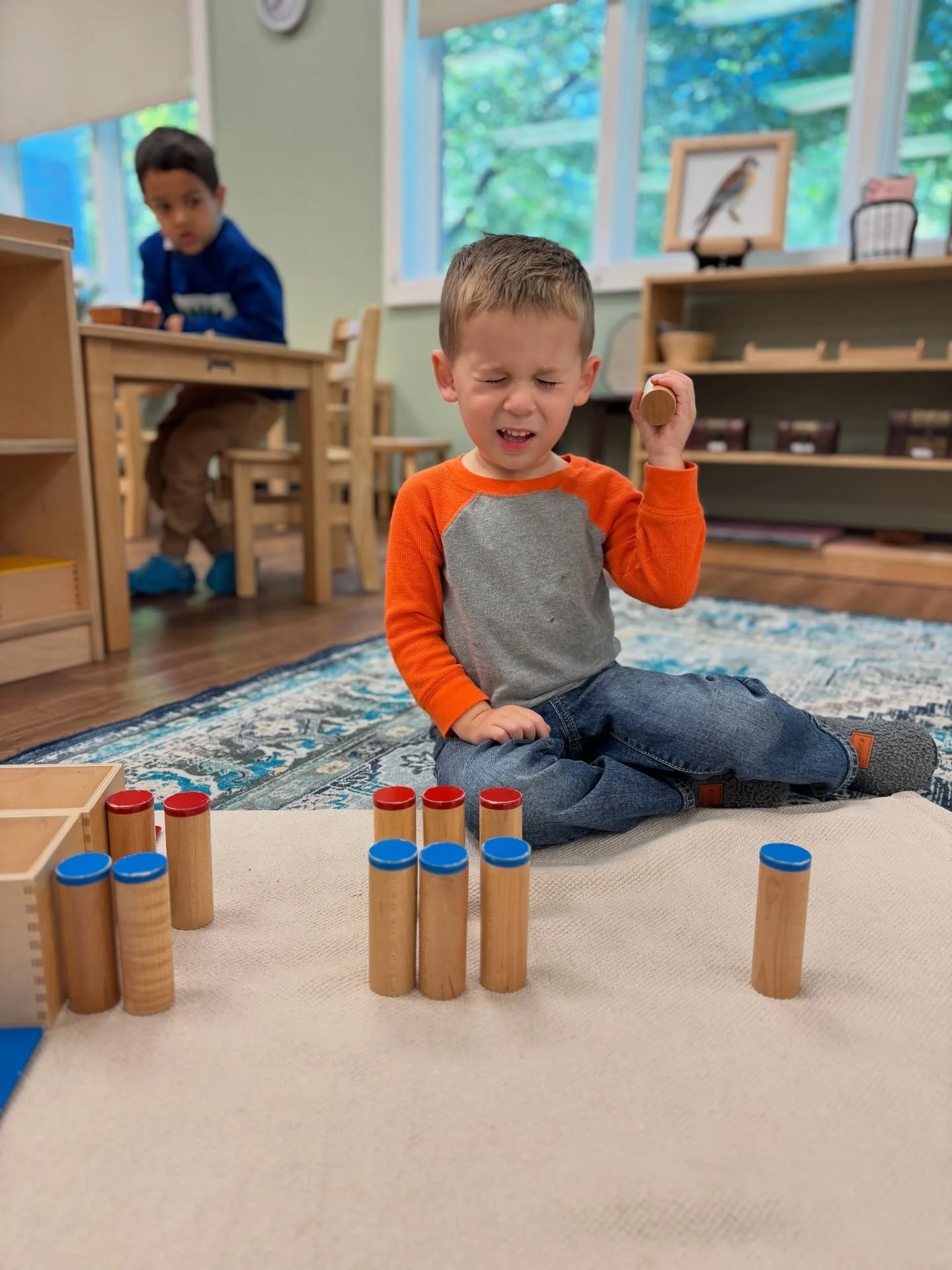 With full focus (and eyes squeezed shut for good measure!), this Children&rsquo;s House friend explores the Sound Cylinders &mdash; a classic Montessori material designed to refine the sense of hearing. By matching cylinders with identical sounds, ch