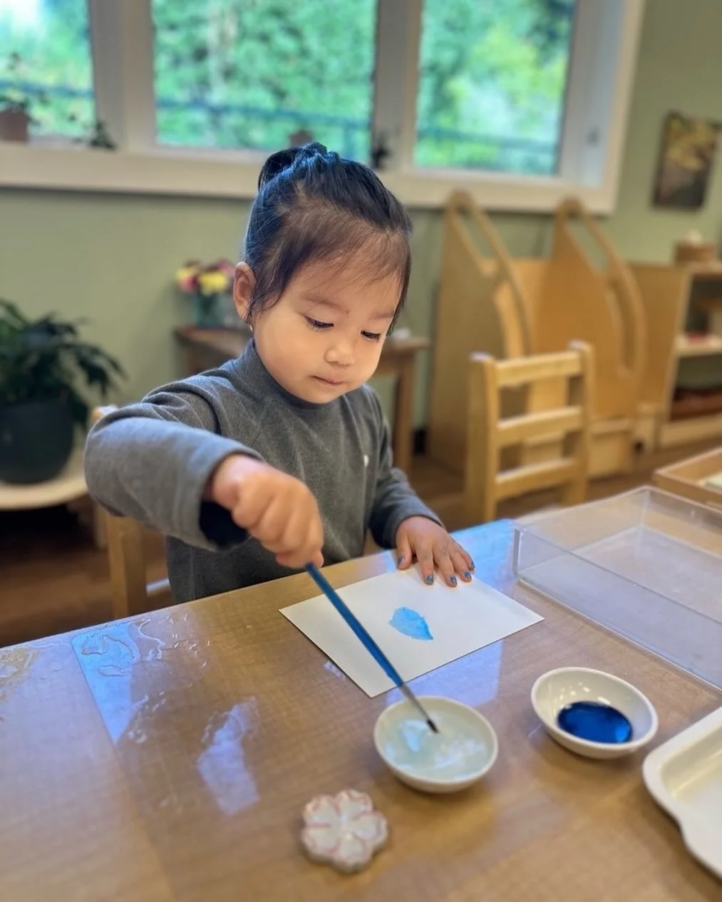 A quiet moment of concentration unfolds as this toddler explores watercolor at their own pace. With each careful stroke, they discover how colors blend, how water moves, and how creativity feels when it&rsquo;s entirely their own. Montessori art expe