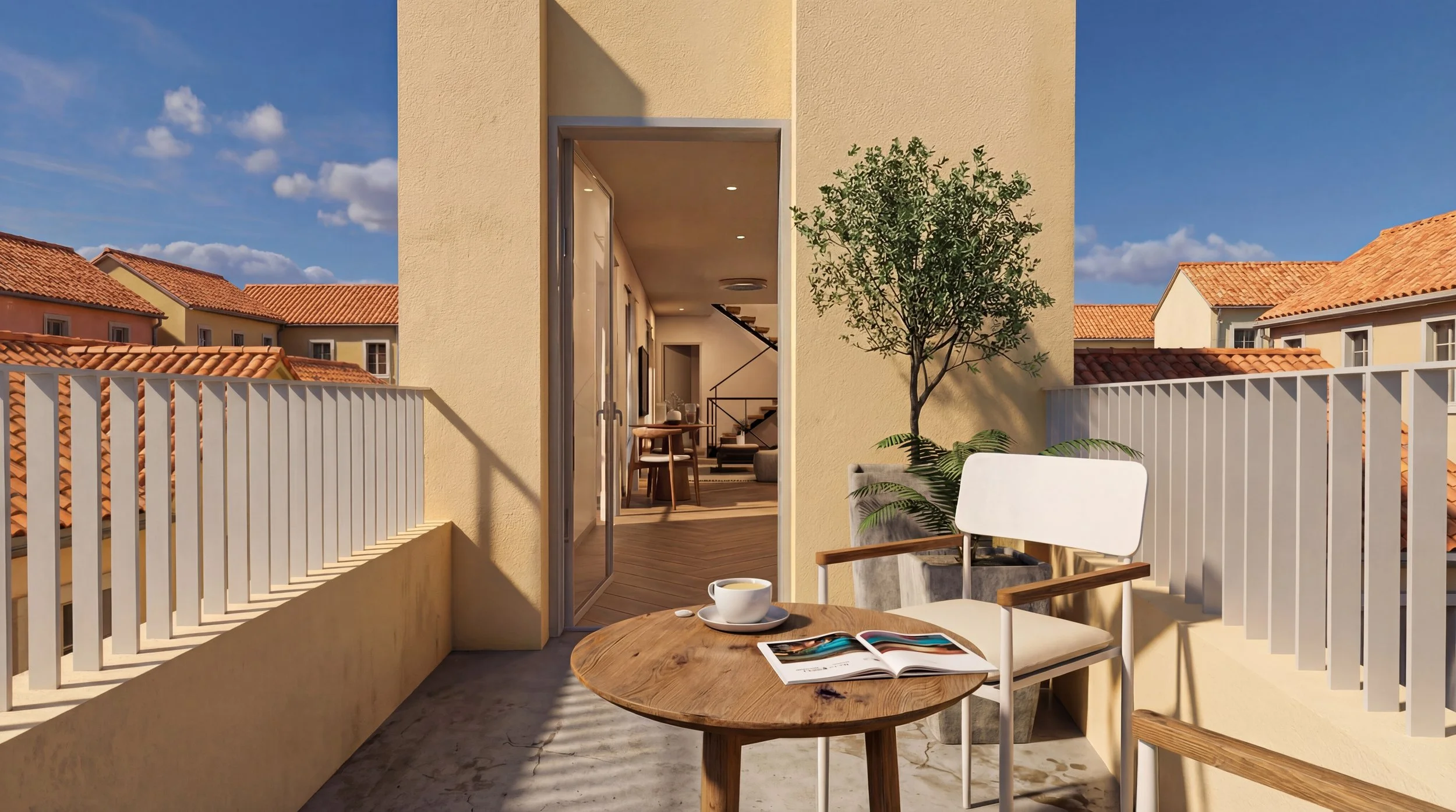 An outdoor balcony with a small round wooden table, a white chair with wooden armrests, a cup of coffee, and an open magazine. A potted tree is next to the table, and the balcony is enclosed by white railing. The interior of the apartment is visible through an open door, showing a dining area and staircase, with neighboring buildings with red-tiled roofs in the background under a partly cloudy sky.