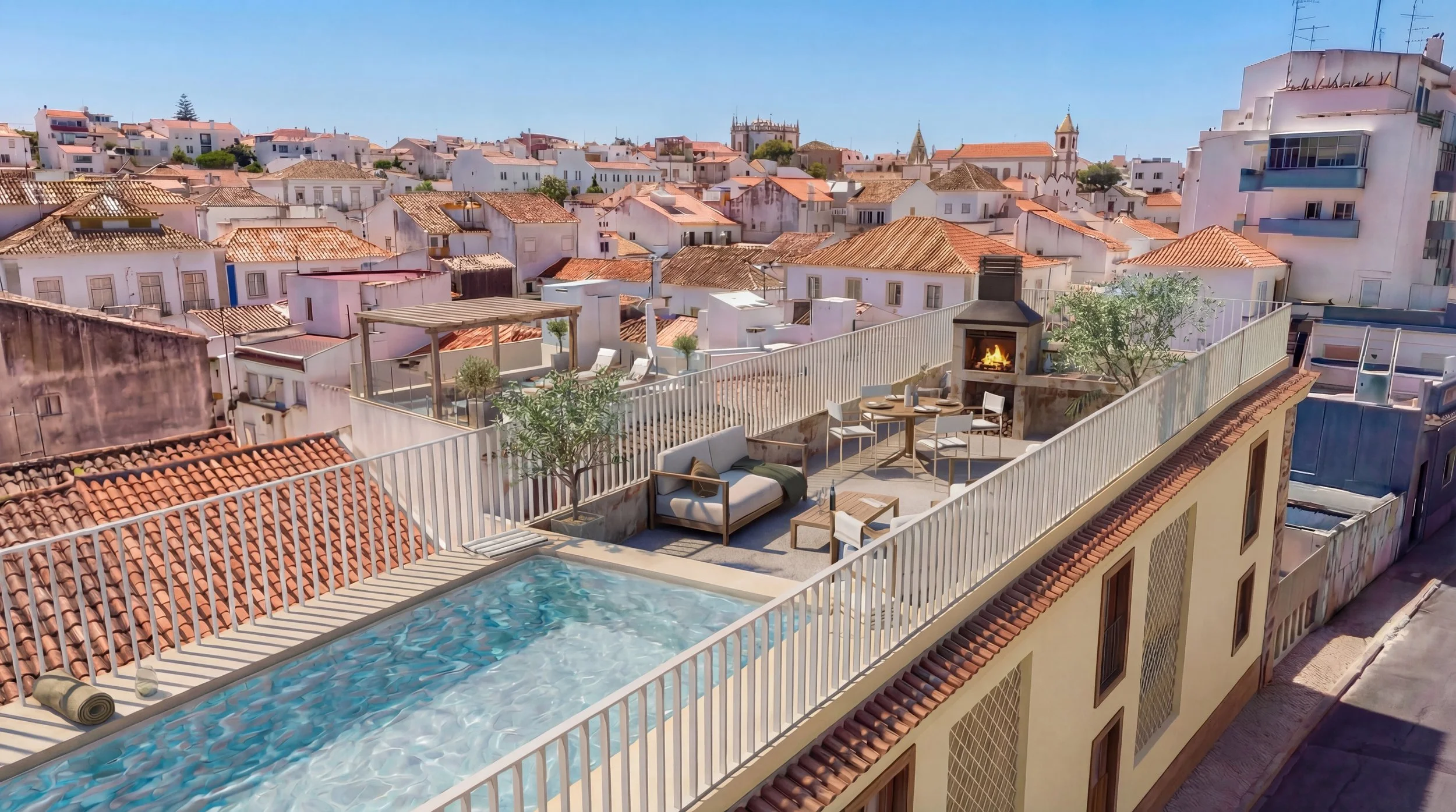 Rooftop terrace with swimming pool, outdoor seating, patio fireplace, and cityscape with white buildings and terracotta roofs