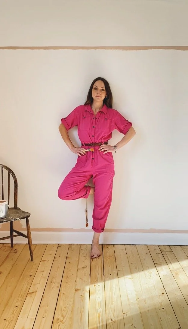 Artist Lynsey Jean Henderson standing in a painted interior