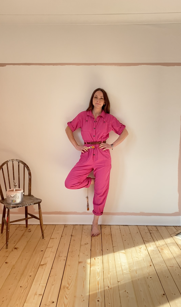 Artist Lynsey Jean Henderson standing in a painted interior