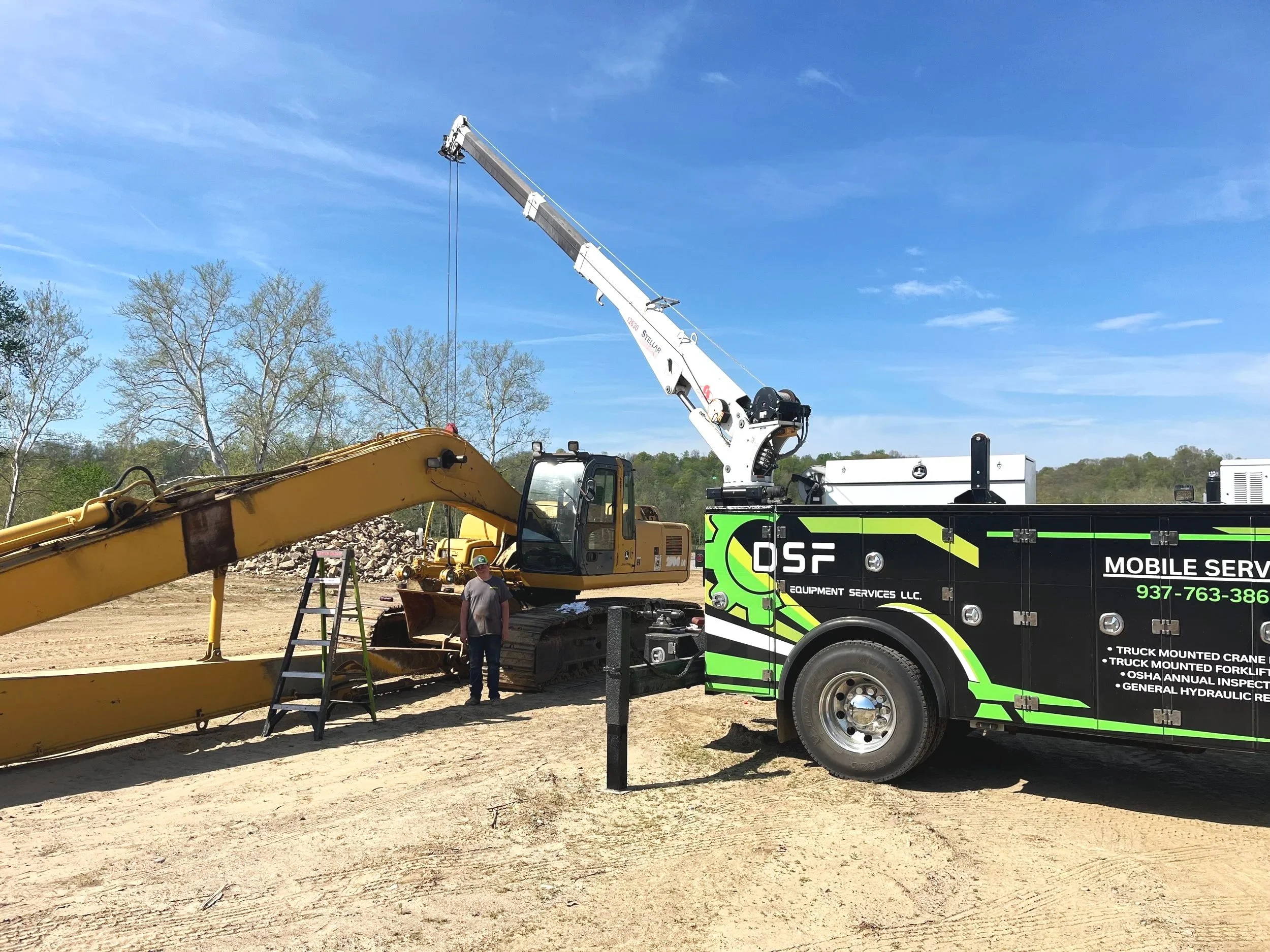 On site hydraulic repair at a dirt jobsite. DSF service truck with Stellar 12630 crane deployed alongside a Deere excavator.