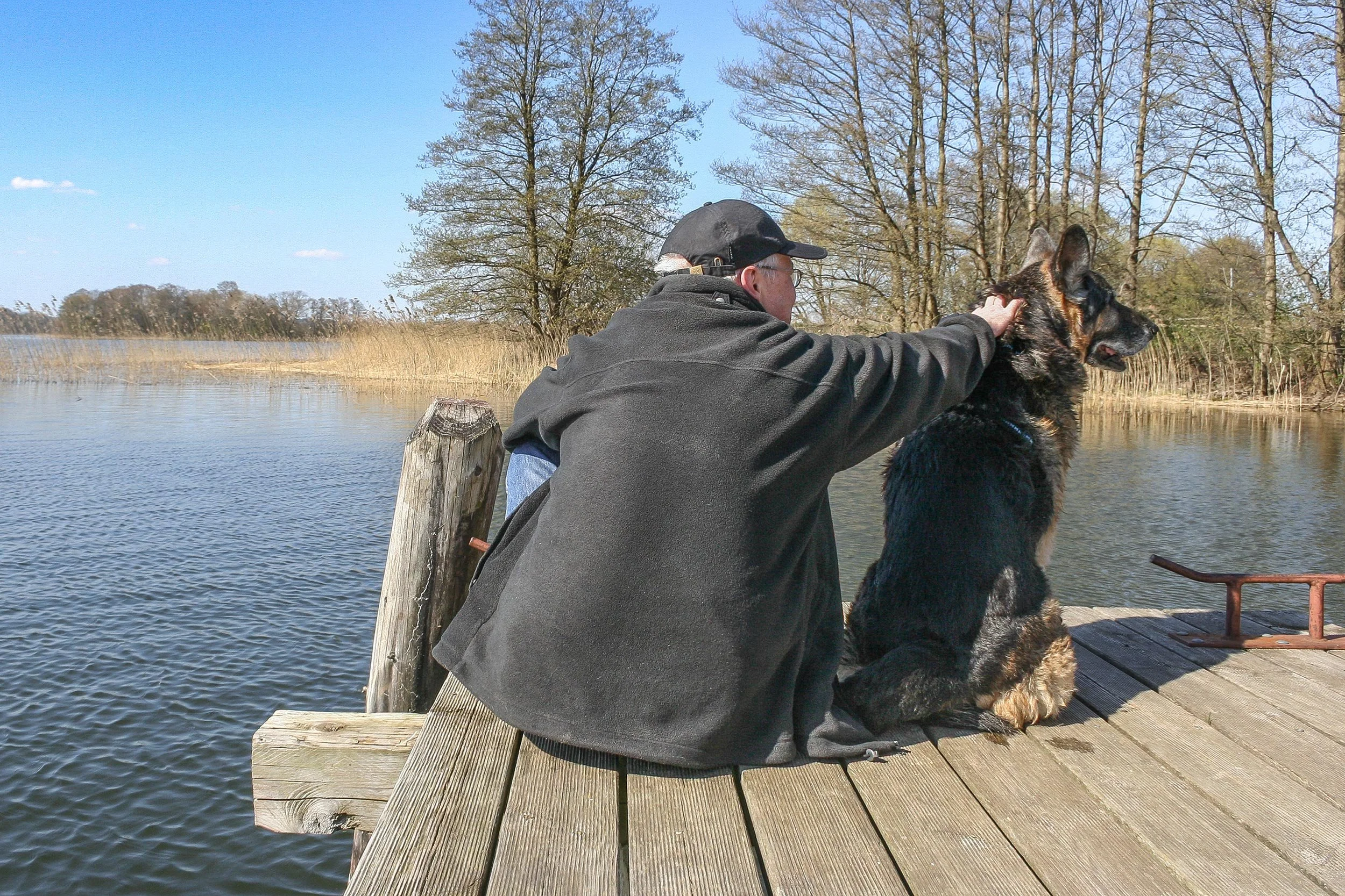 Schäferhund Asco mit seinem Herrchen auf einem Steg am Serrahner See.