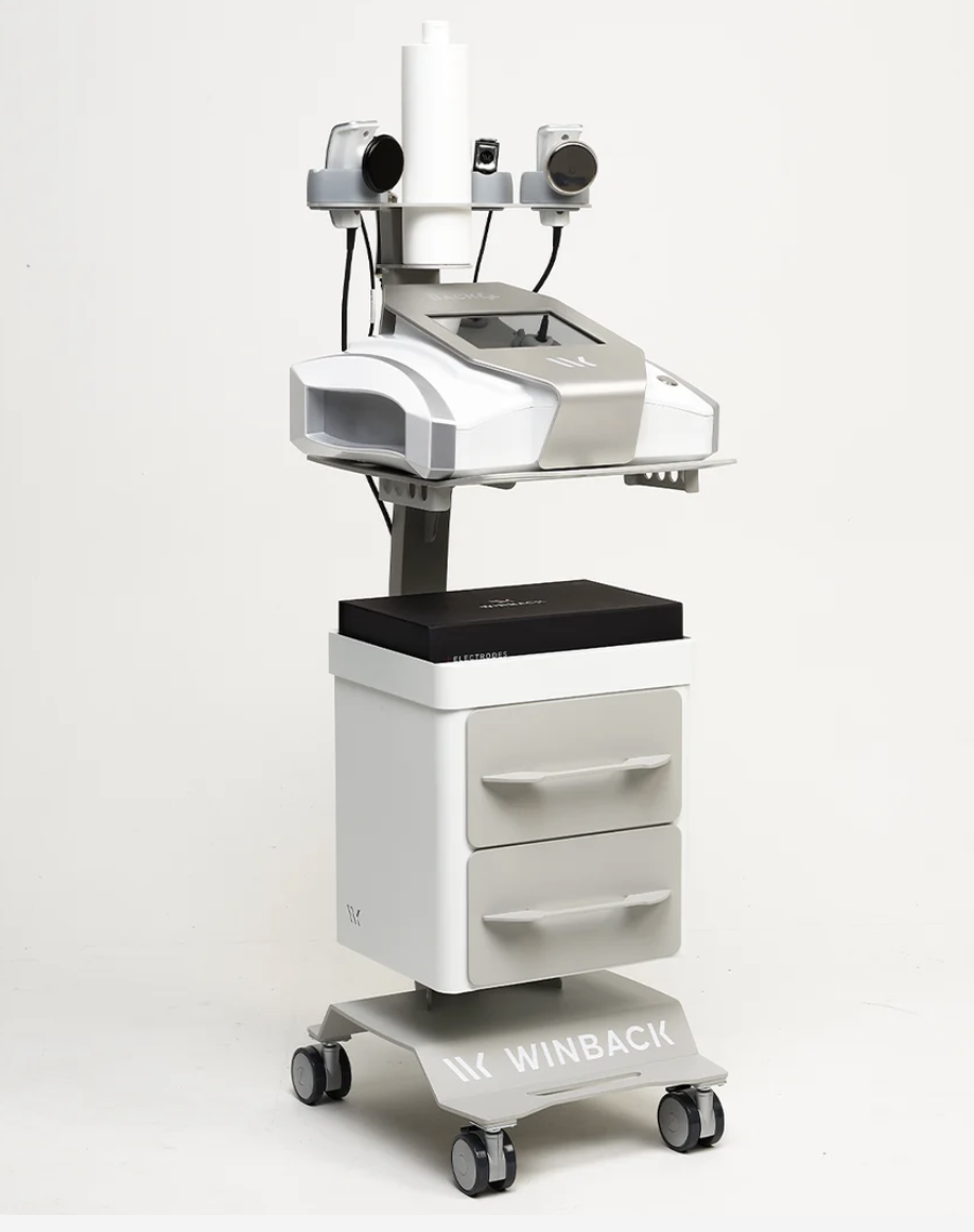 Medical device on a mobile cart with control screen, sensors, and a camera, labeled 'WINBACK'.