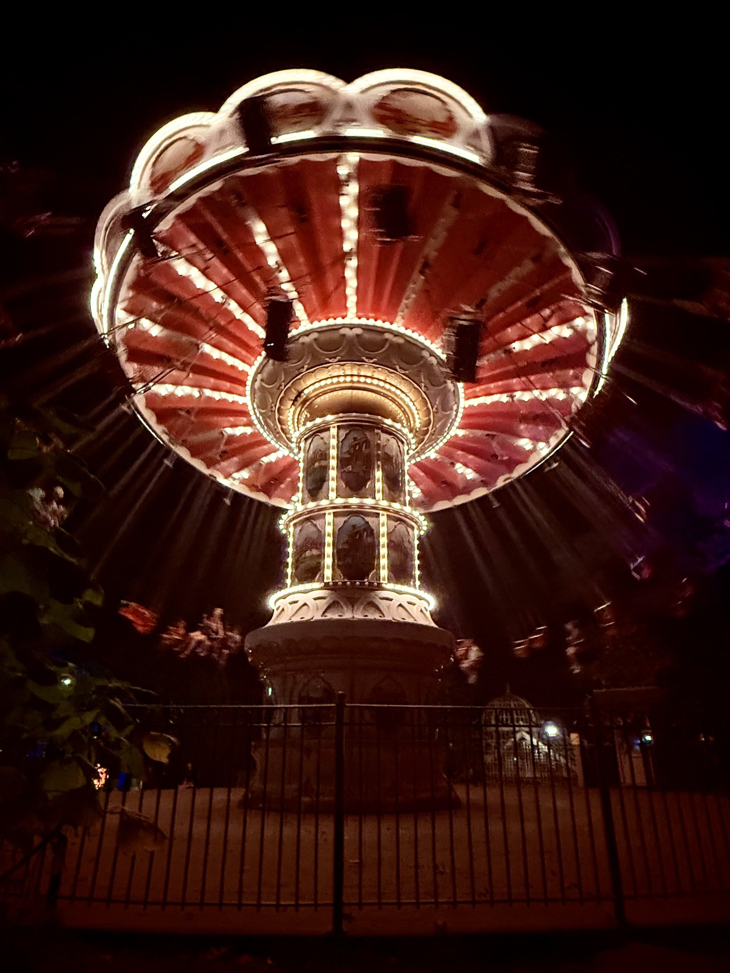 Illuminated swing ride at night in an amusement park.
