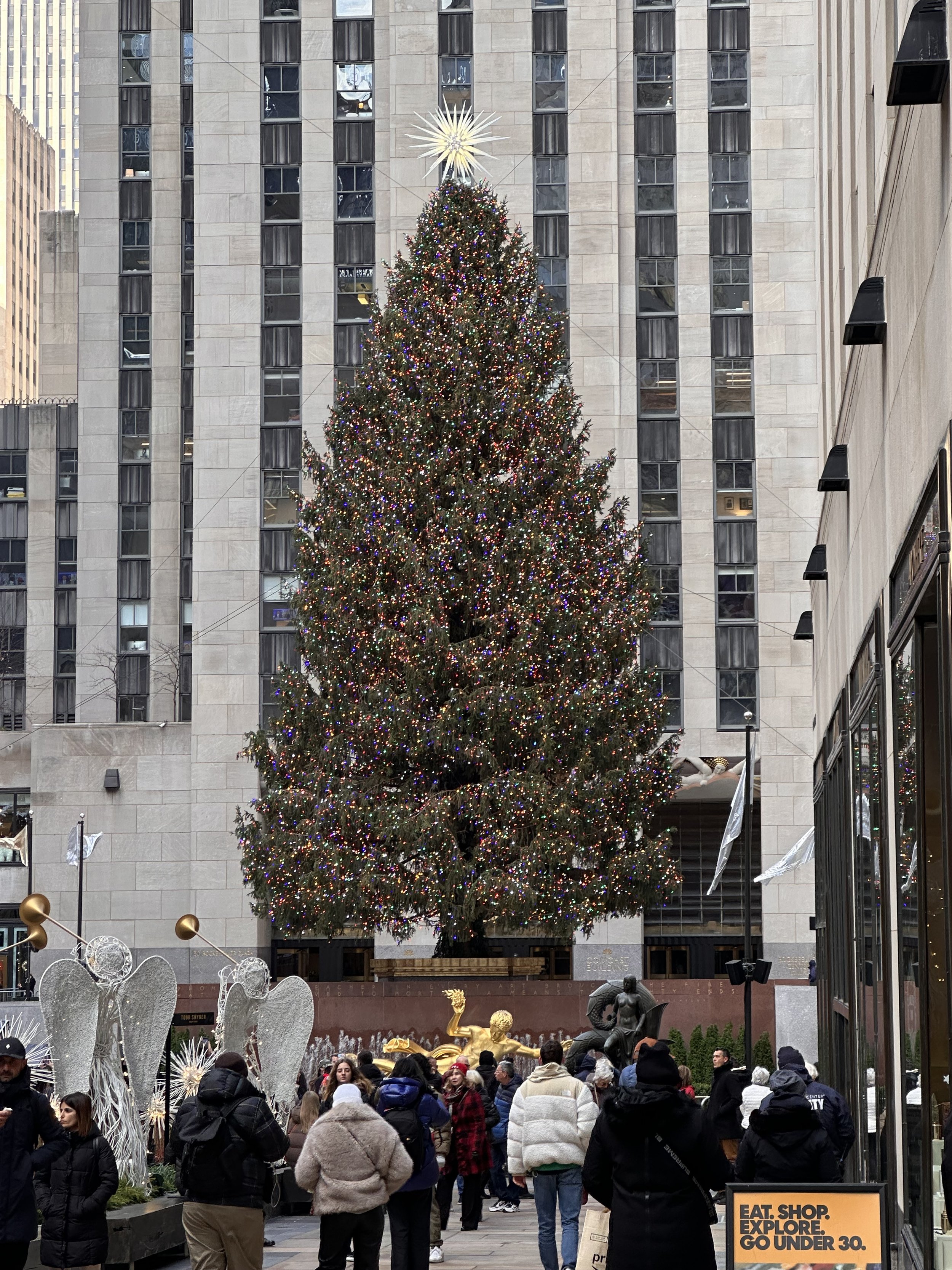 Christmas tree at Rockefeller Center with decorations and a crowd
