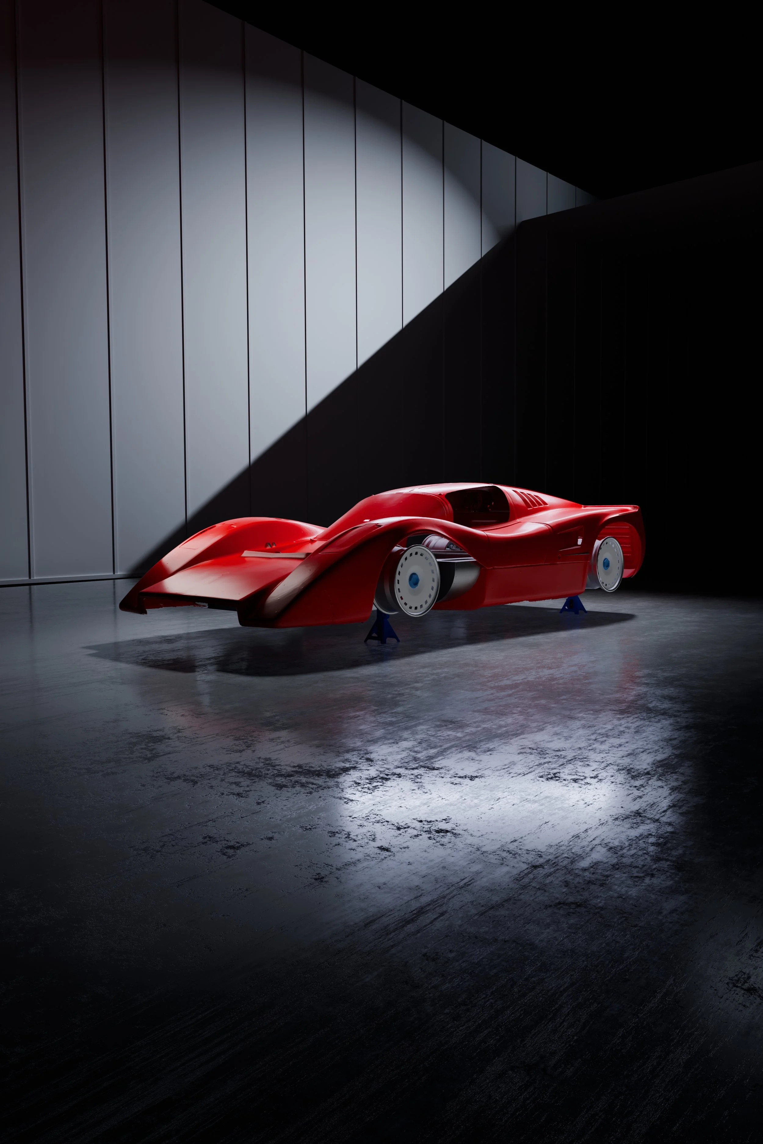 A sleek,  Manta Mirage race car prototype in an industrial setting, displayed without wheels and supported on blue stands, with dramatic lighting highlighting its streamlined design.
