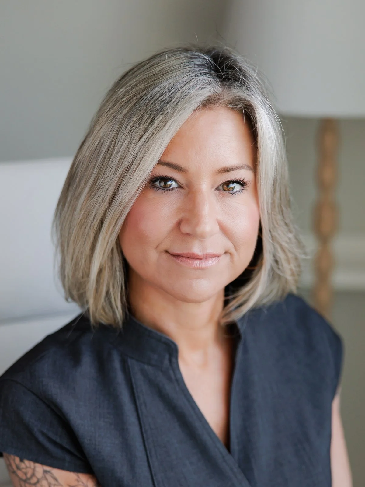 Tamara Robb, paralegal at Hepburn and Glass in surrey bc. A close-up portrait of a woman with shoulder-length gray hair, wearing a black top, smiling softly with a neutral background.