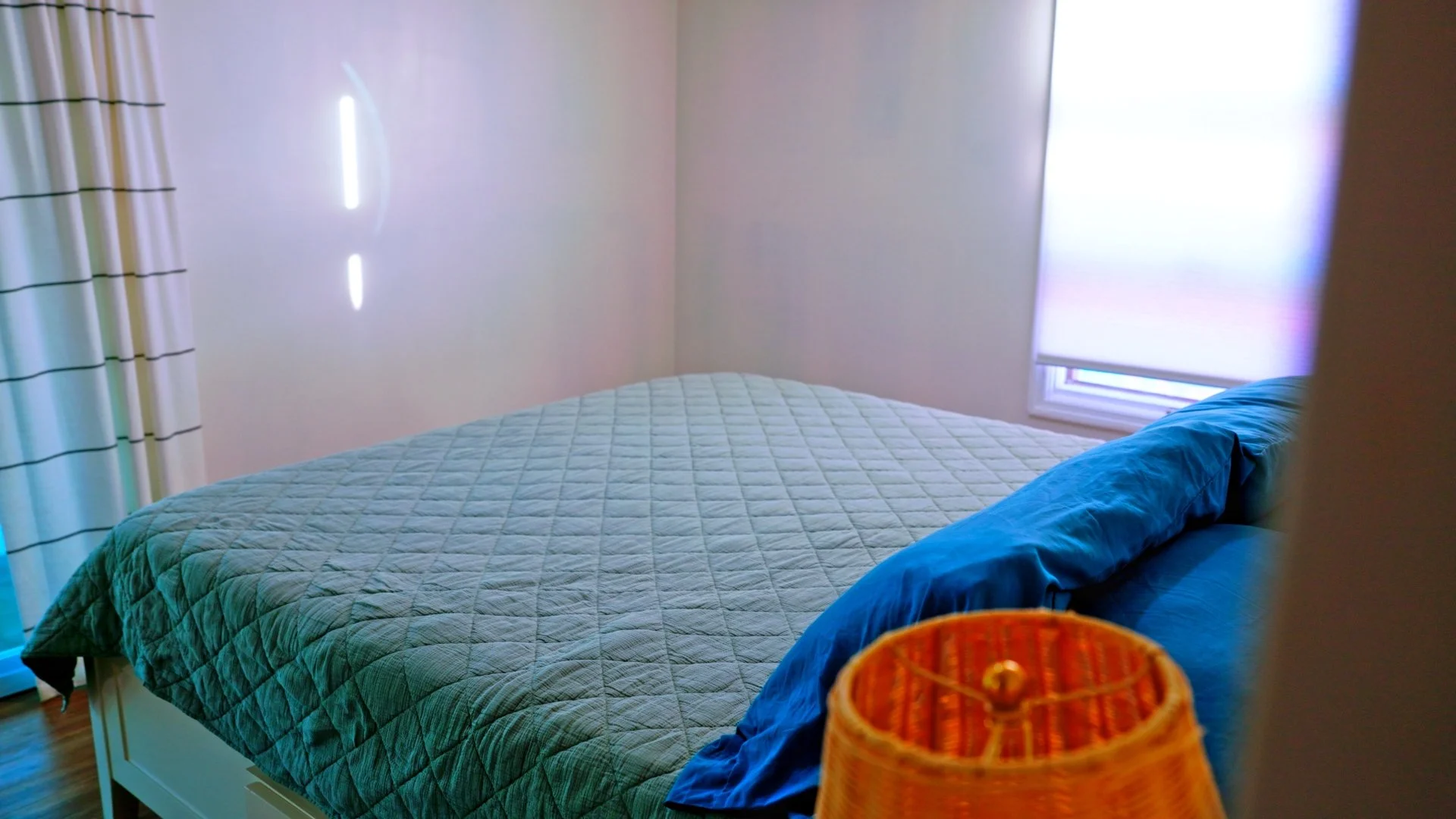 Bedroom with green quilt and tropical decor at B Happy Beach House on Green Turtle Cay.