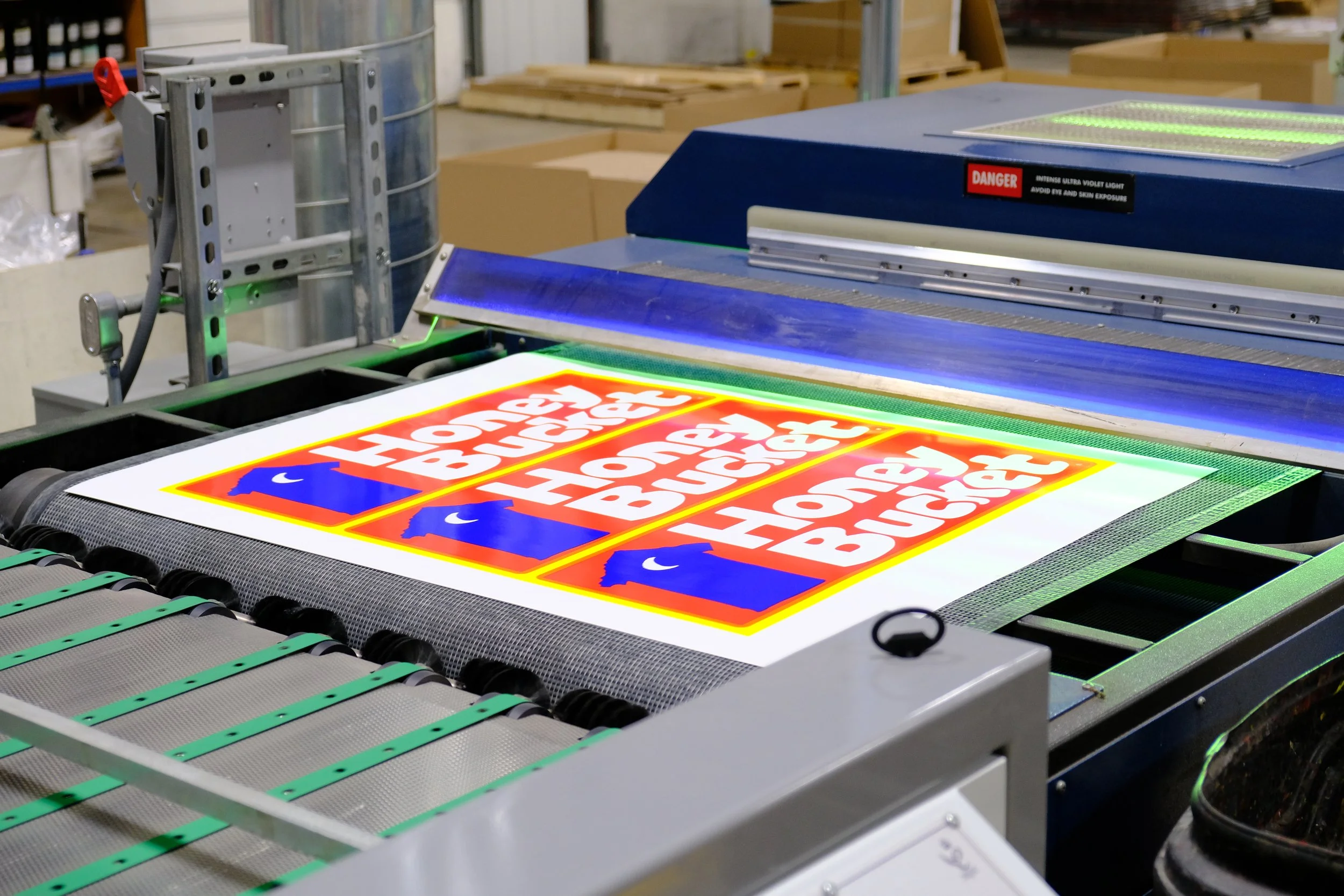 Front section of a white Isuzu PortaPros delivery truck with company branding and contact information on the door.